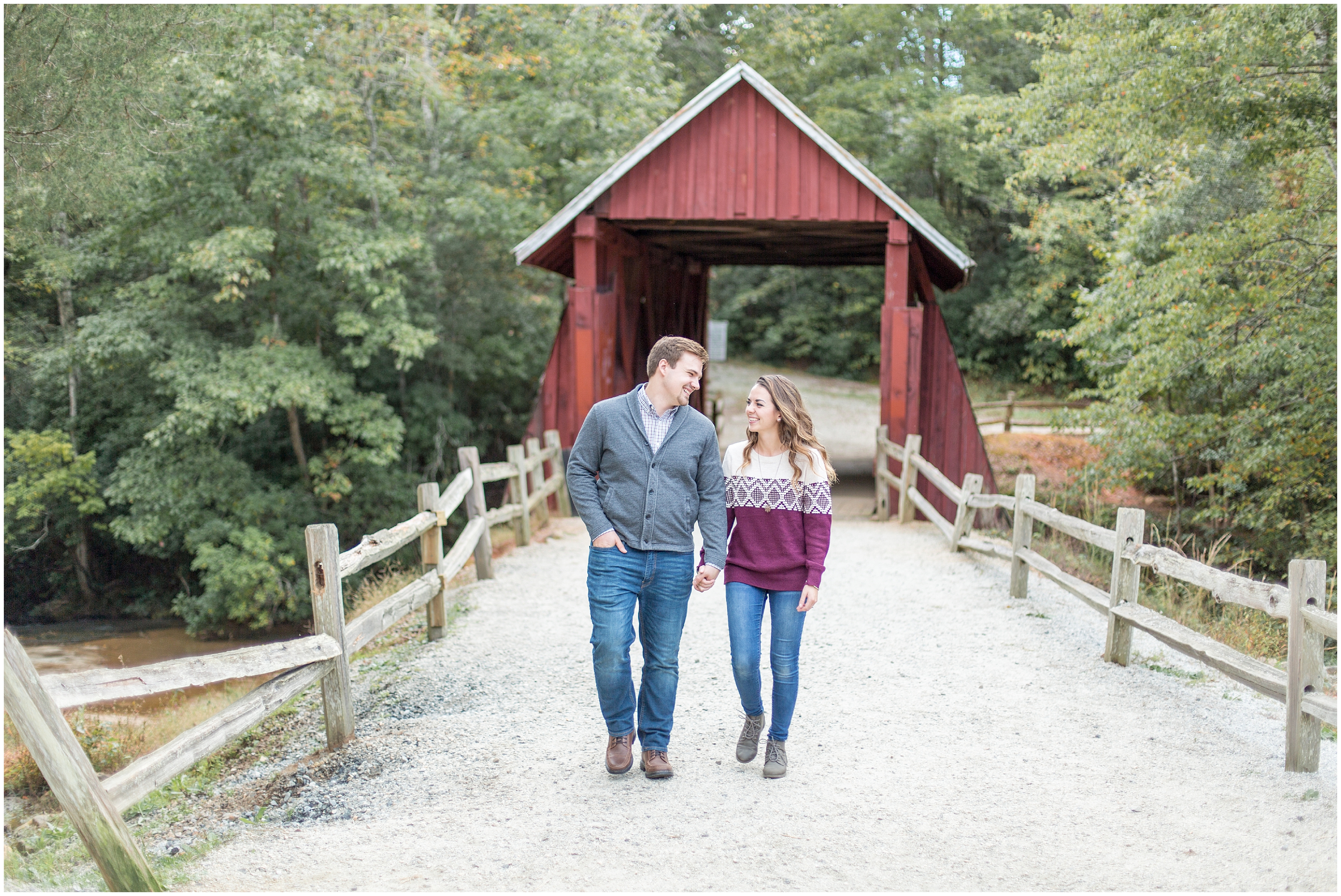 Couple walks away from red covered bridge in Greenville SC during engagement session