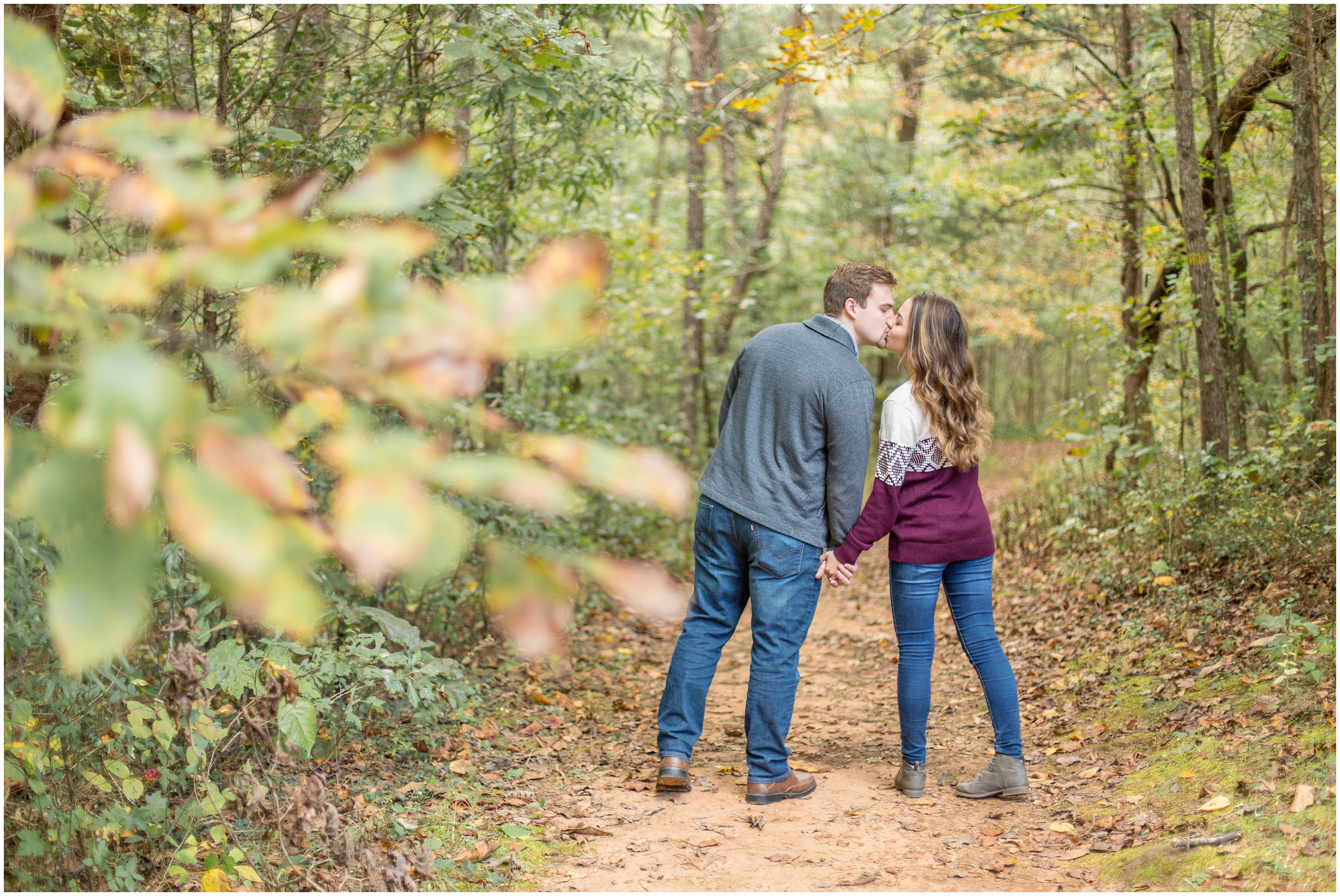 couple sneaks in a kiss walking along trail in SC
