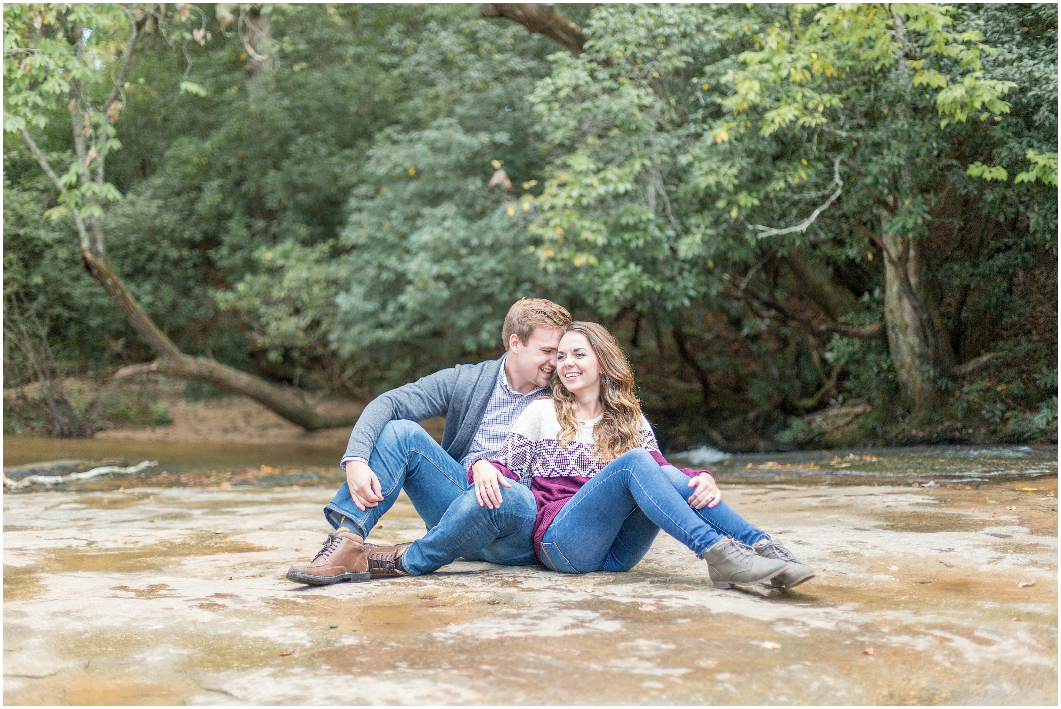 engaged couple sits on ground during engagement session in SC
