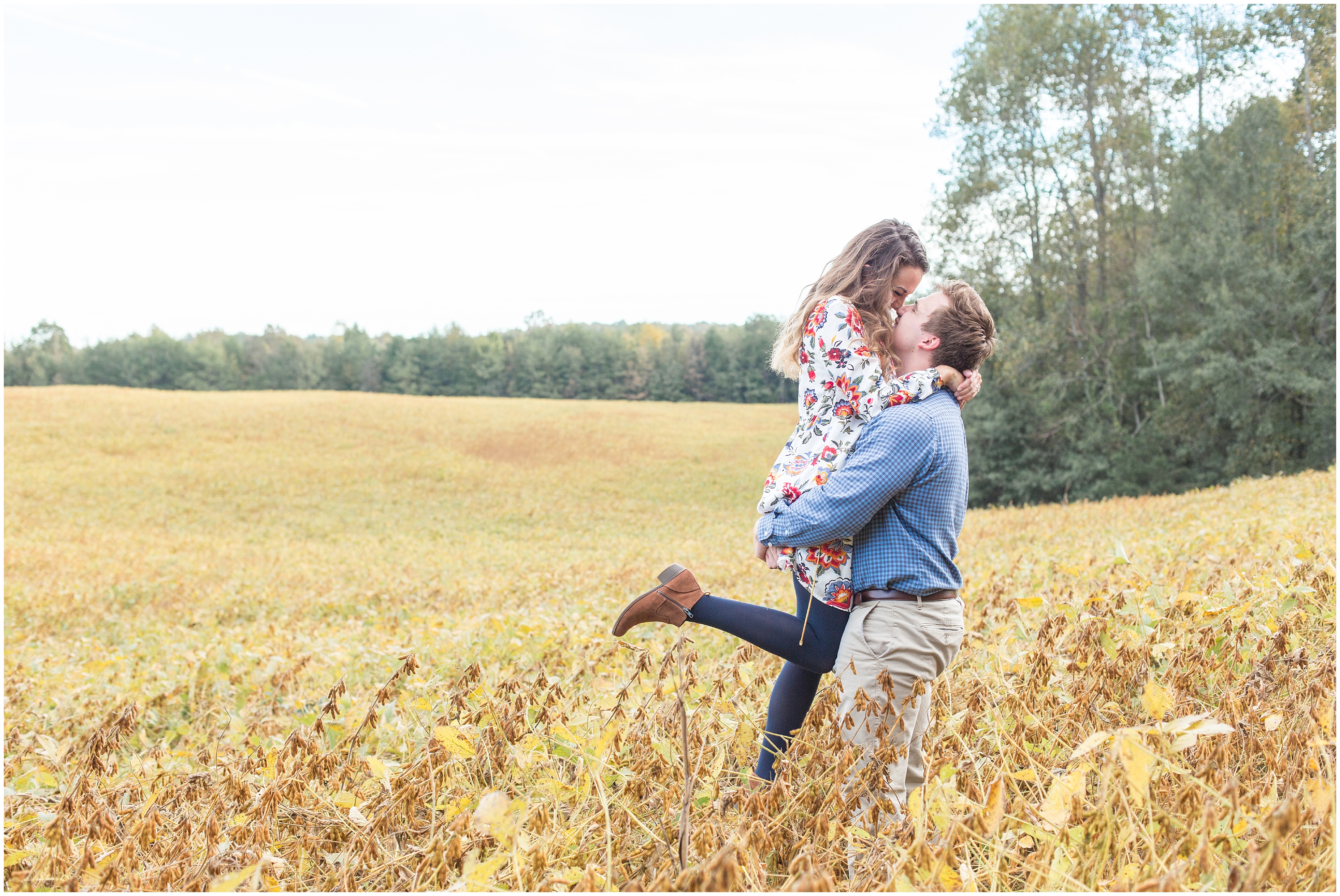 man lifts fiance up in tall grass in SC during engagement session