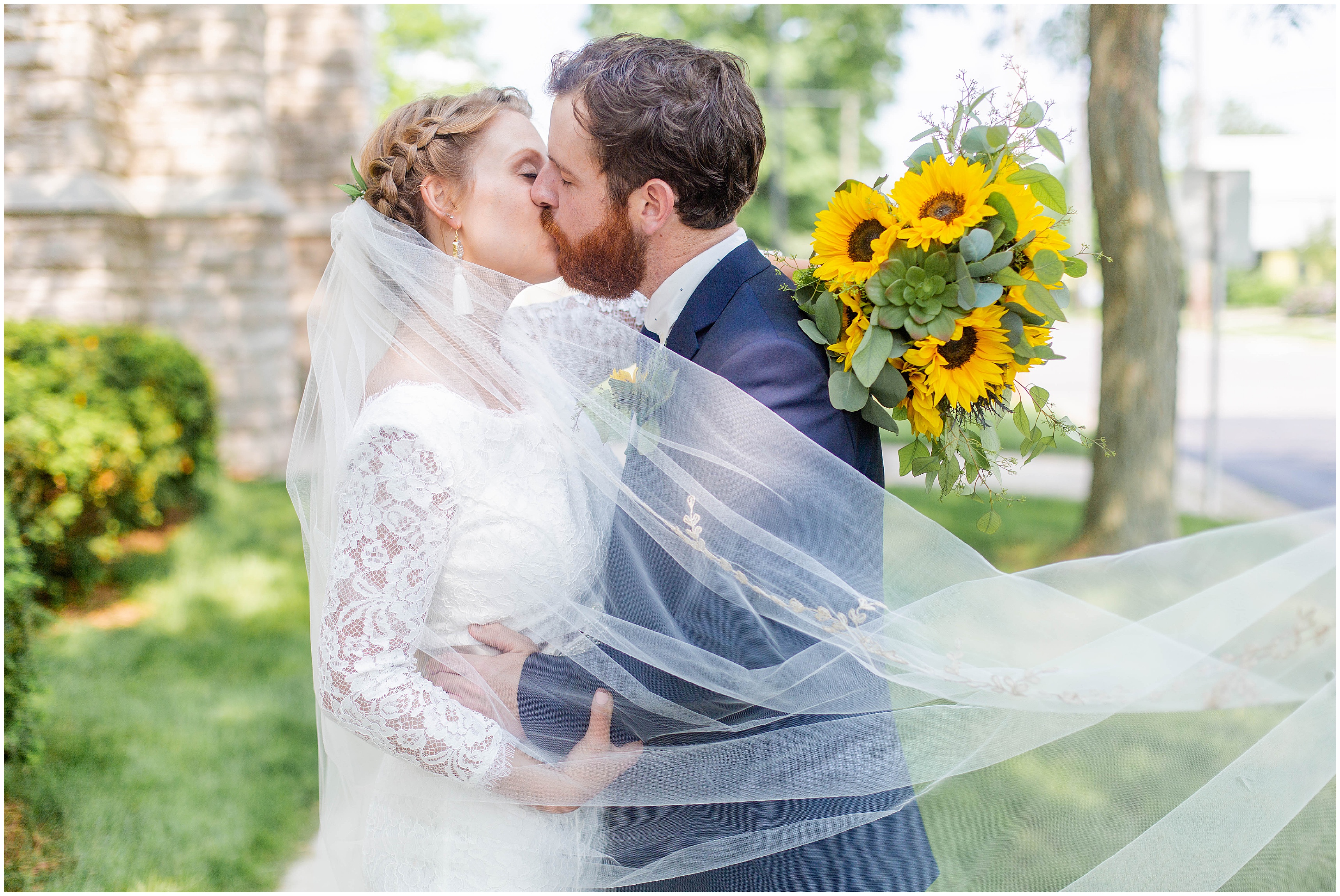 bride + groom kiss with veil flowing around them 