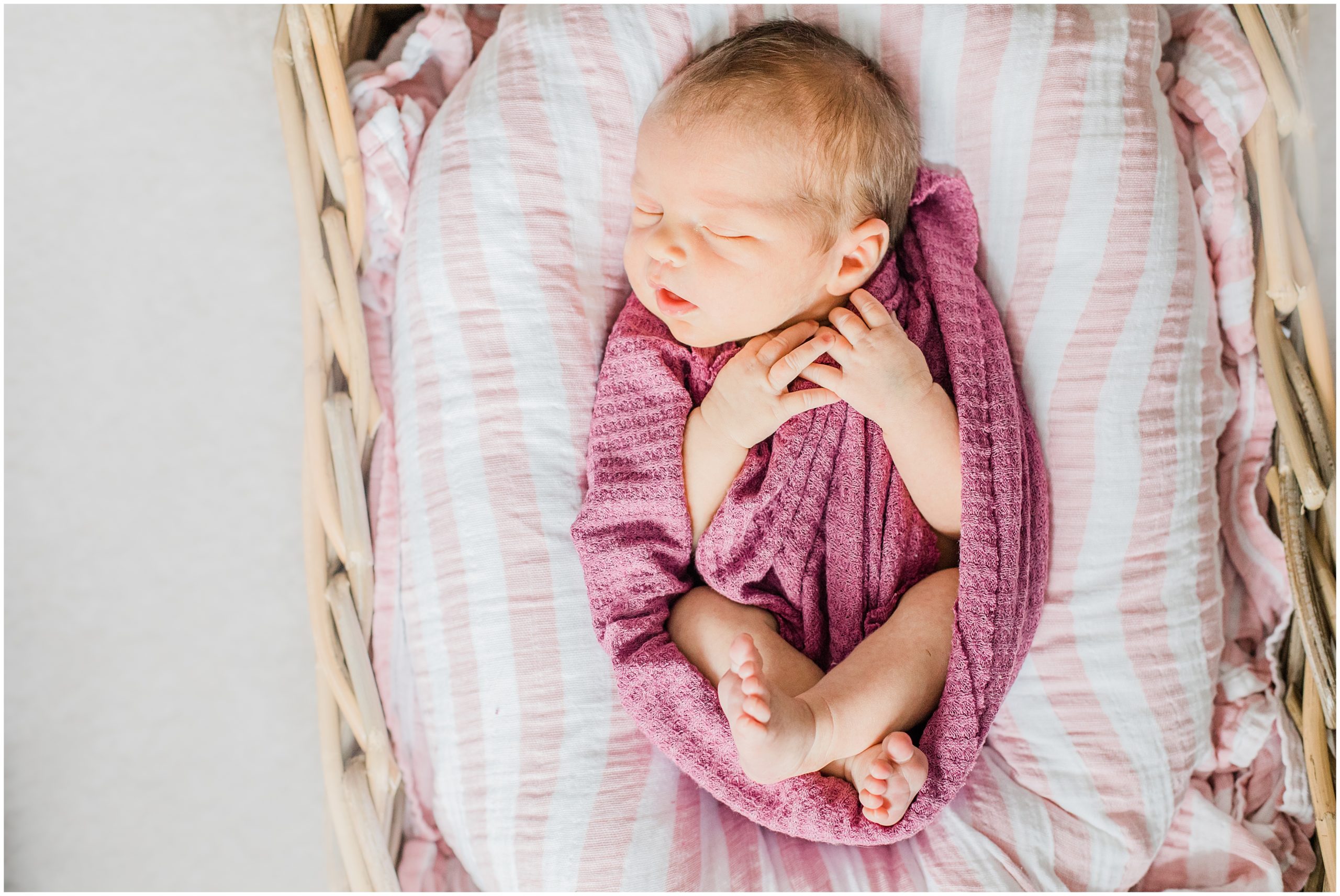 baby lays in hot pink wrap during newborn photos with Morgan Amanda Photography