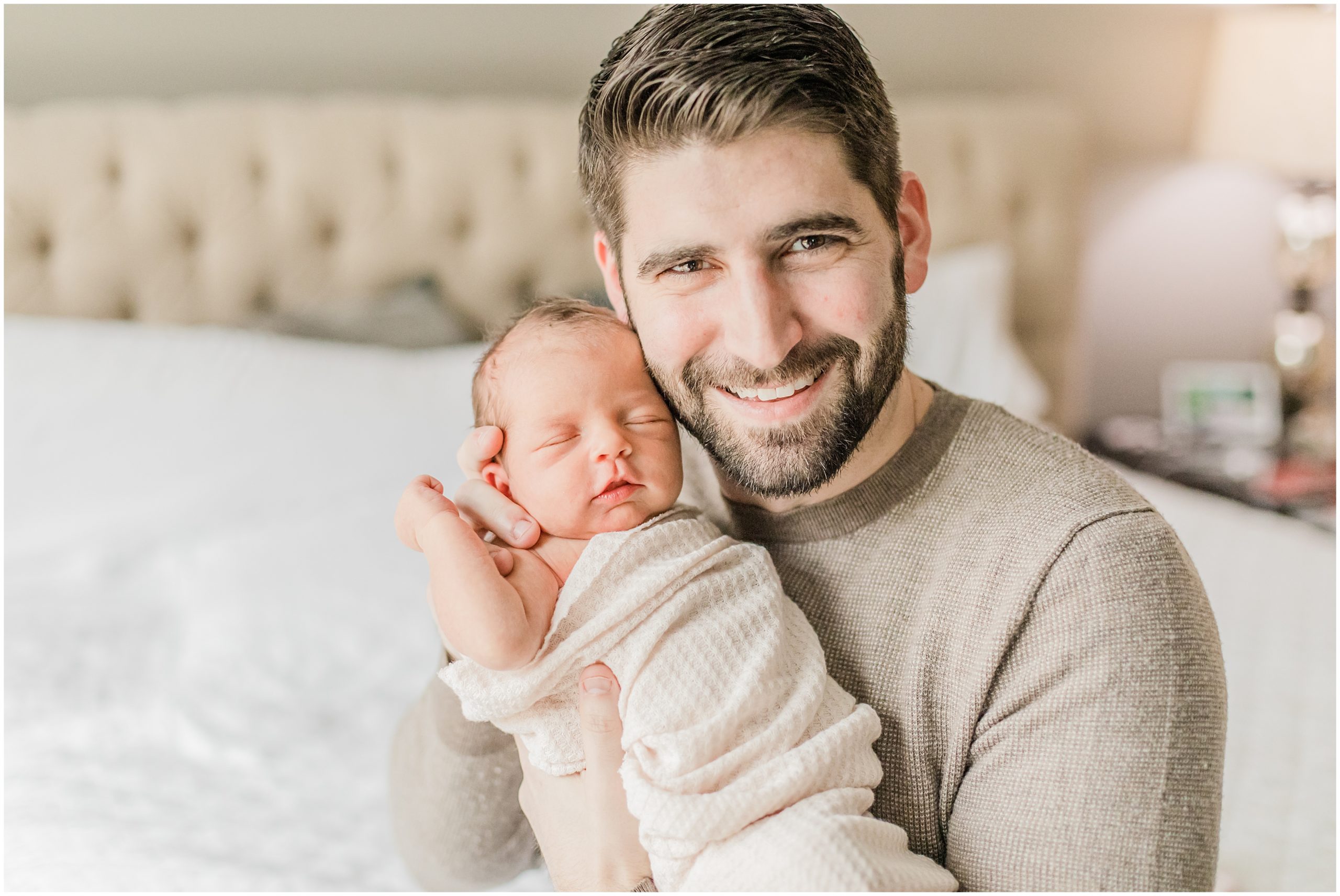 dad holds newborn daughter during Lifestyle Newborn Session in Charlotte