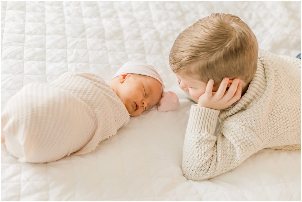 brother looks at baby sister during Charlotte NC newborn photos
