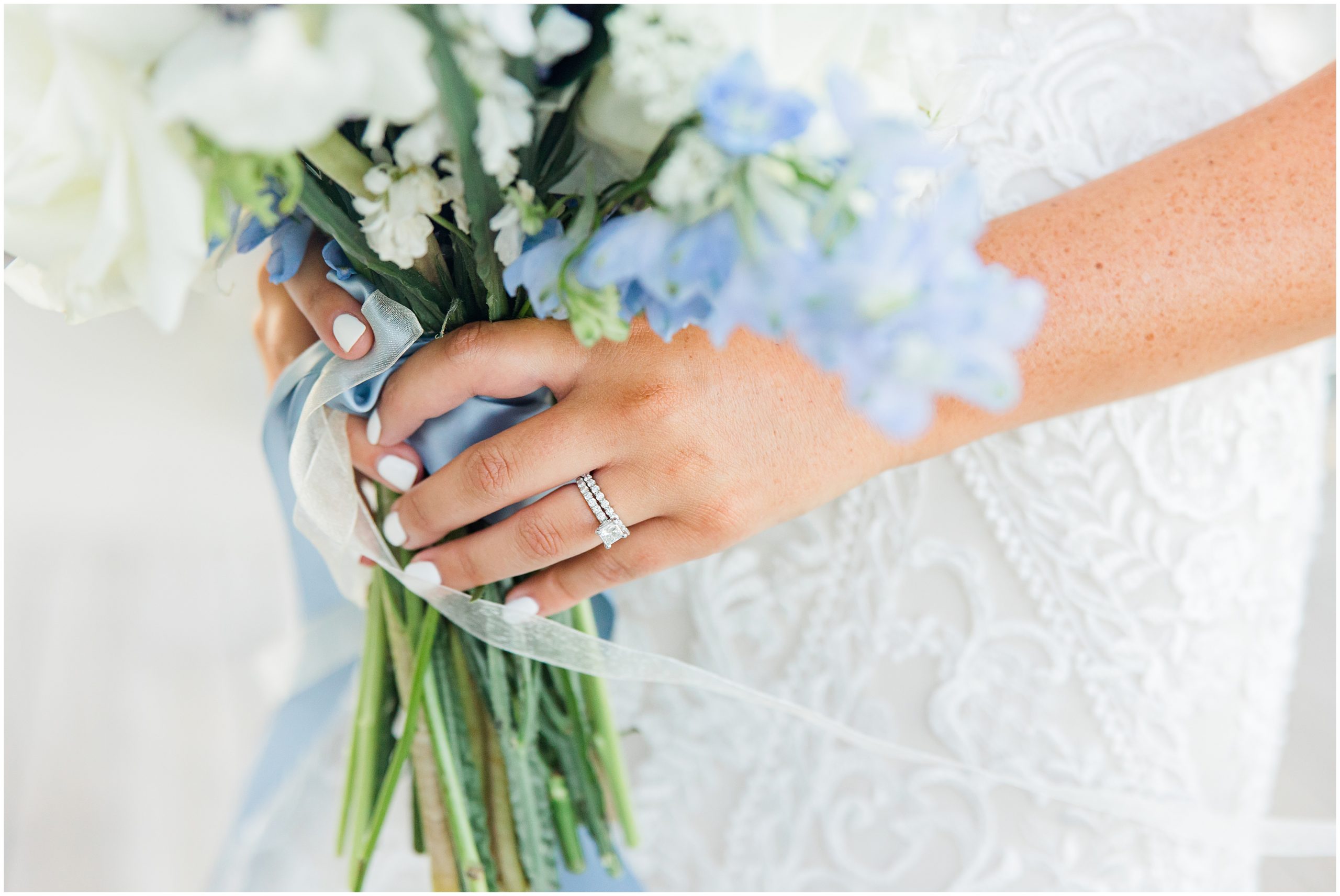 bride holds bouquet with white and blue flowers at Jennette's Pier
