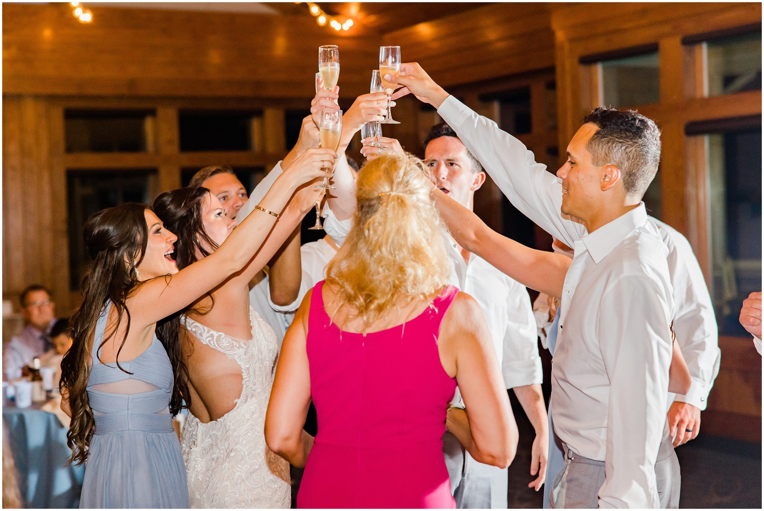 bride and groom toast with wedding party during NC wedding reception 
