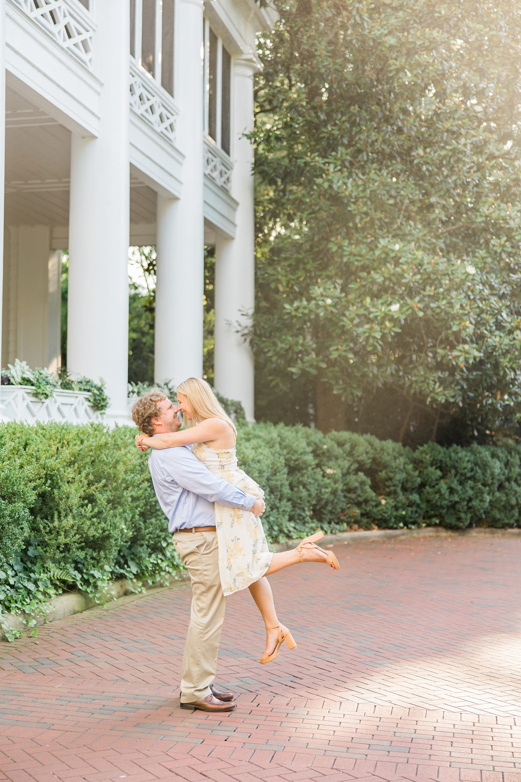 groom lifts bride up during sunset engagement photos in Charlotte NC