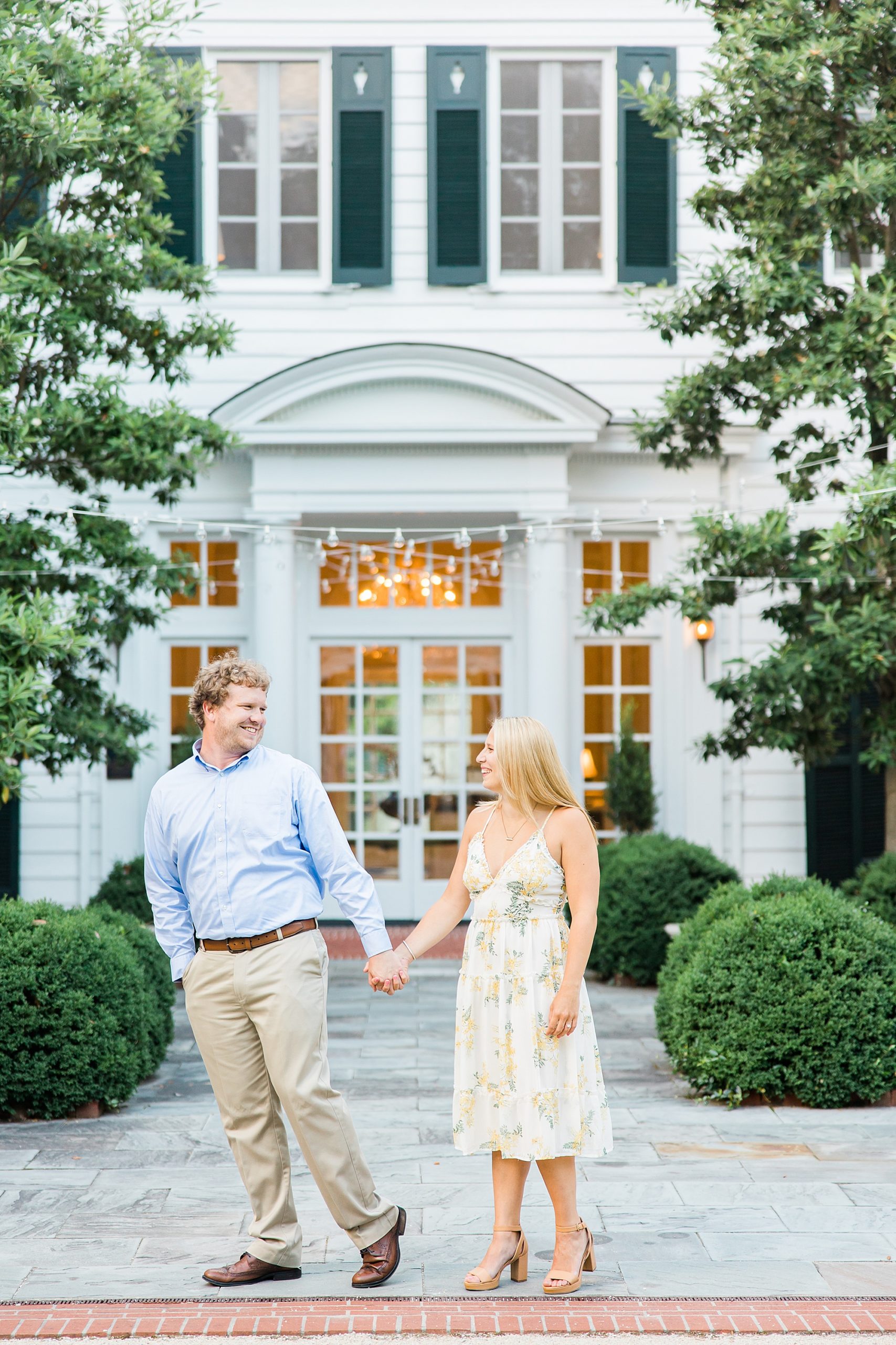 bride and groom hold hands walking outside the Duke Mansion