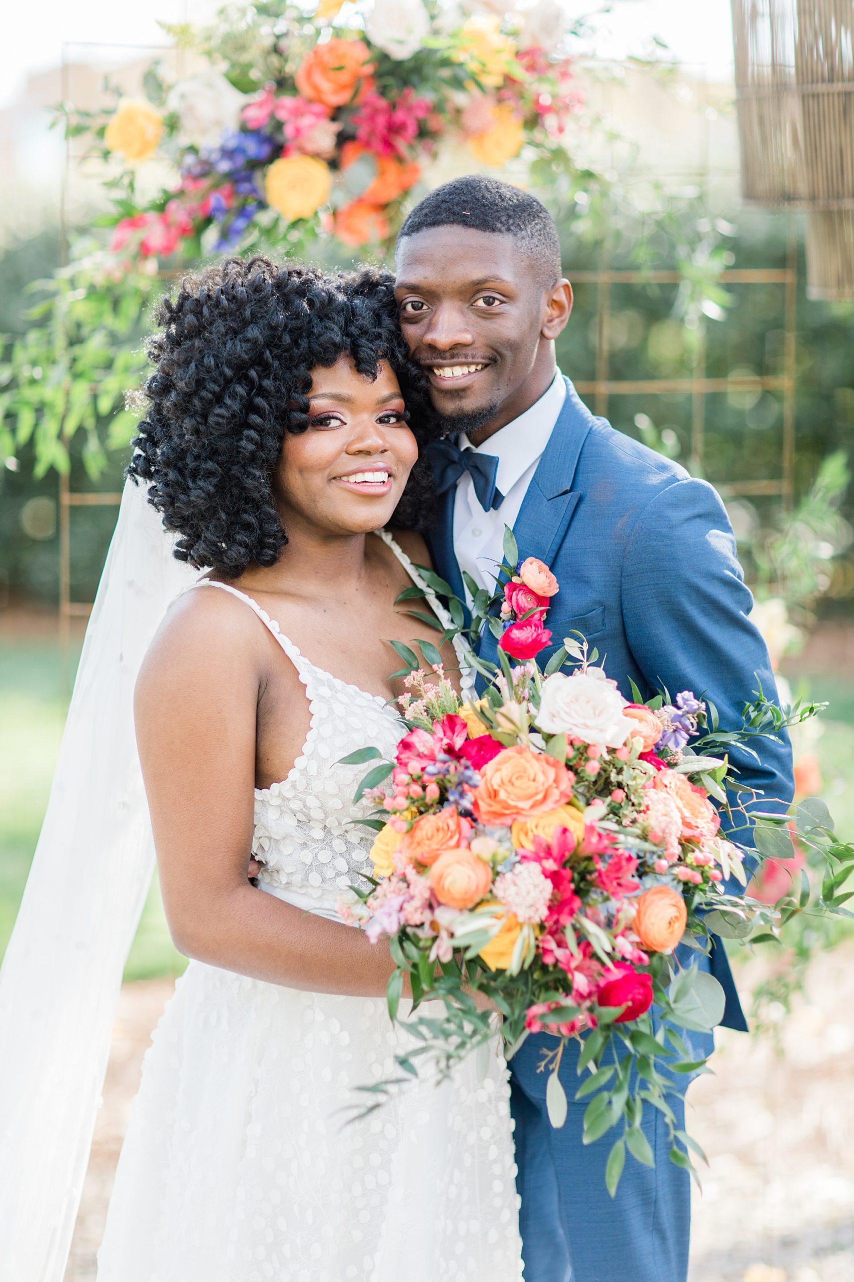 newlyweds pose with bride holding pink and orange bouquet in Charlotte NC