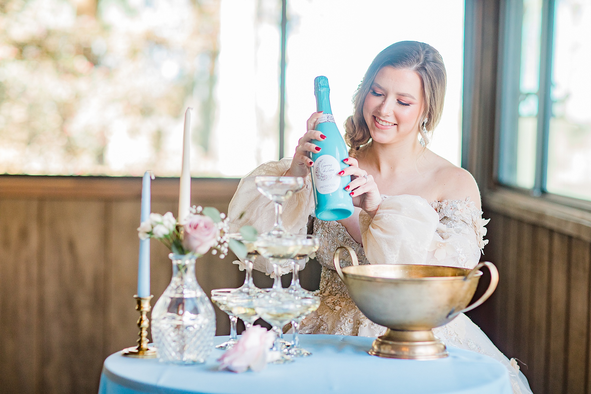 bride looks at champagne bottle during styled shoot