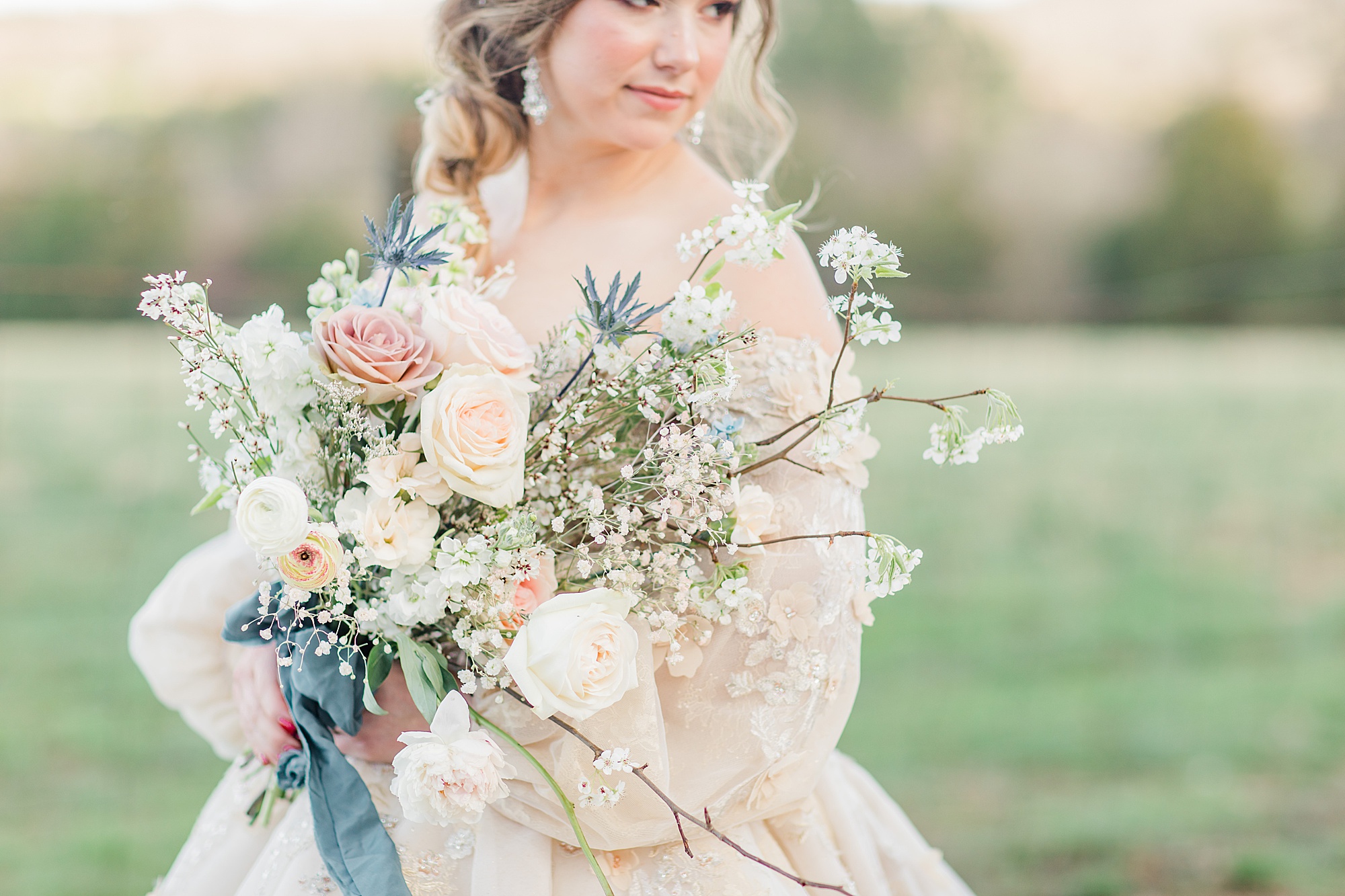 bride holds bouquet with pastel flowers