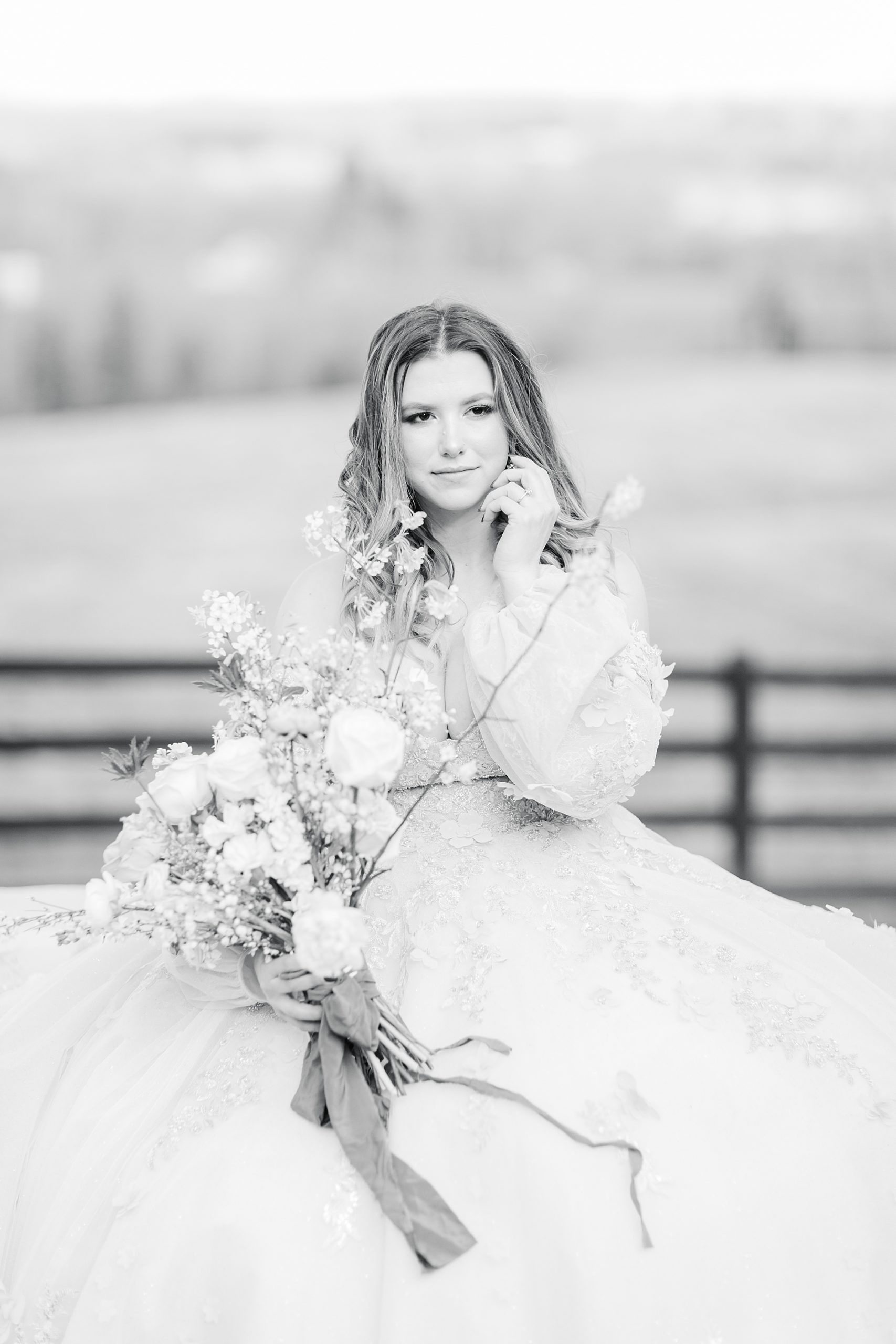 bride holds bouquet posing by wooden fence at Carolina Country Weddings