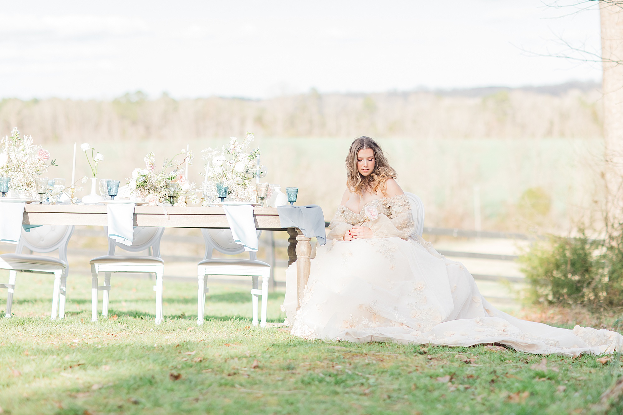 bride sits at reception table outdoors at Carolina Country Weddings