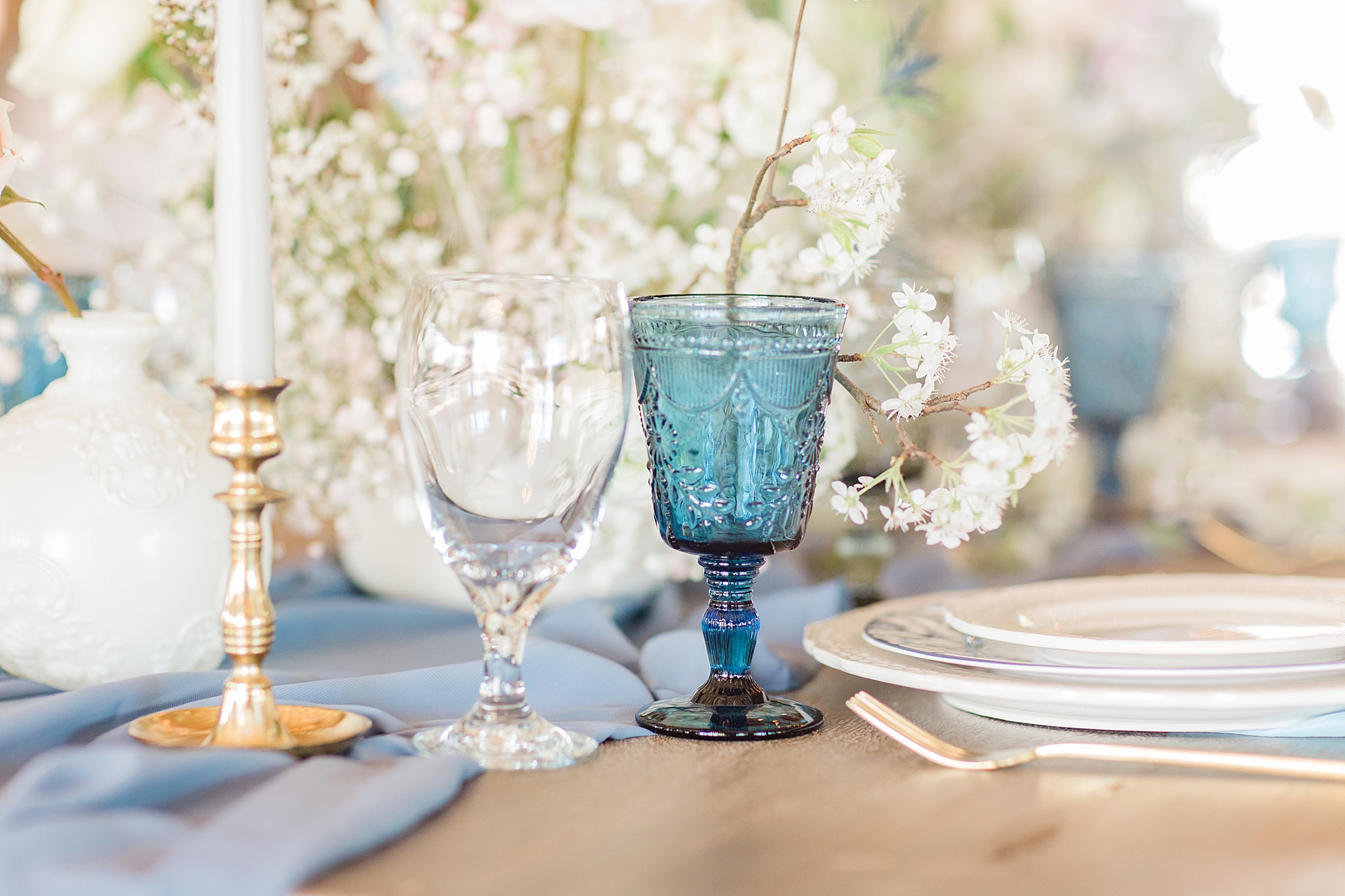 wedding reception place settings with vintage blue glasses
