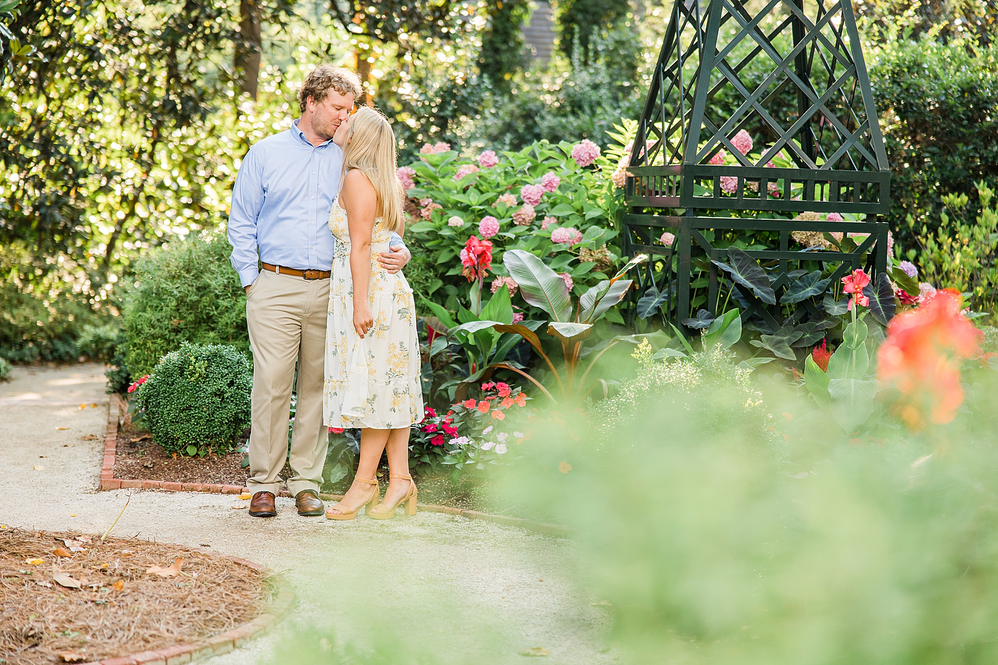 engaged couple poses in Duke Mansion gardens