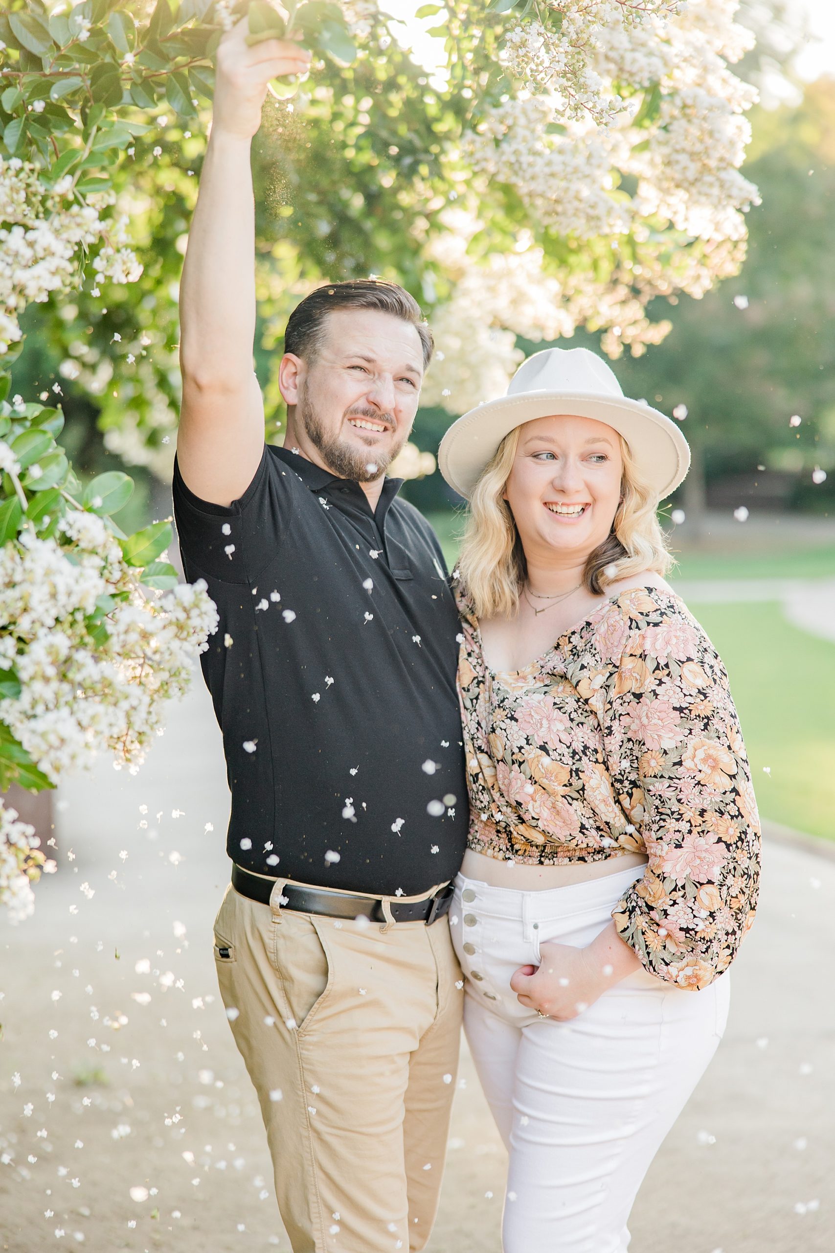 groom shakes tree so petals fall during engagement photos 