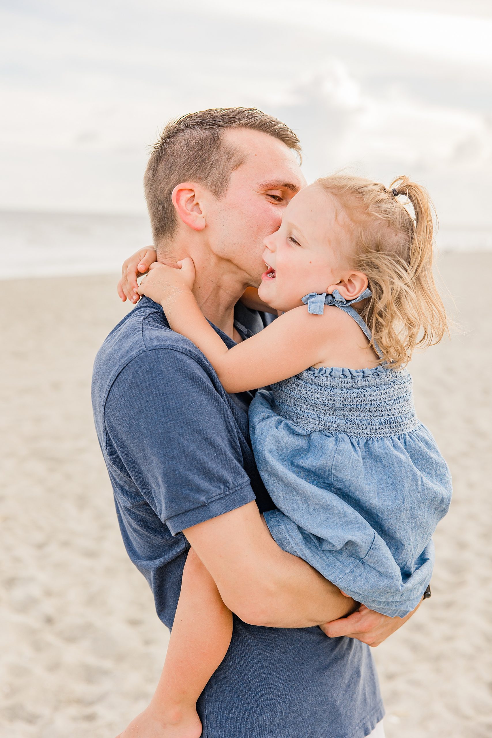 dad kisses daughter during beach family photos