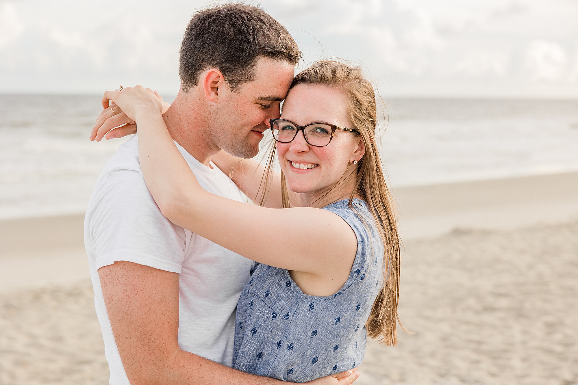 young couple poses on the beach during Holden Beach family photos