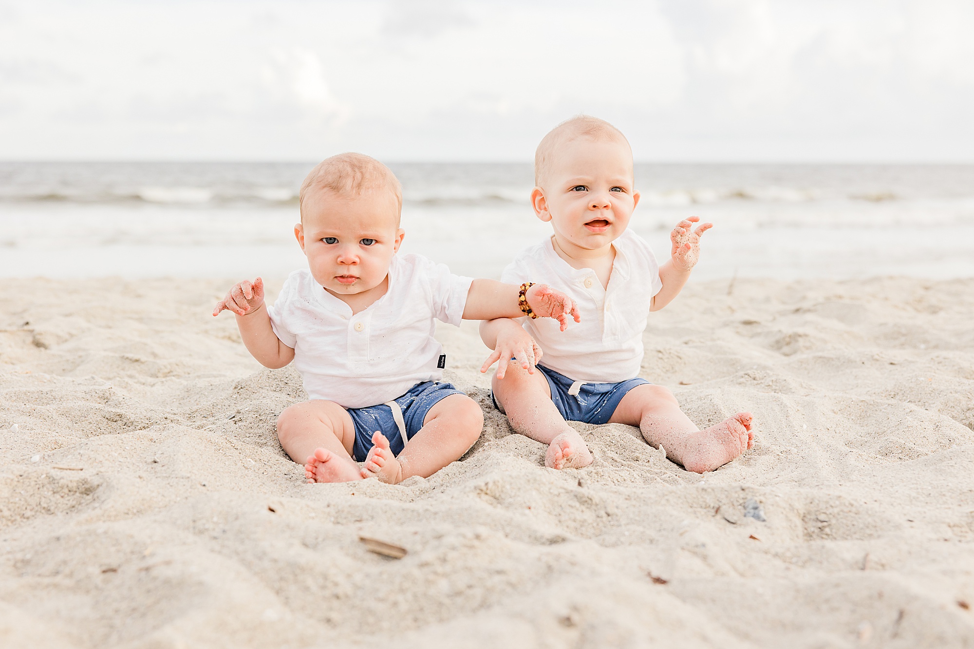 toddlers play in sand together during Holden Beach family photos