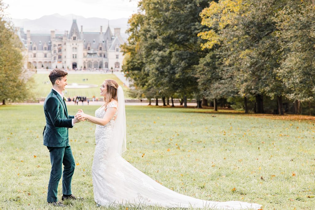 bride and groom hold hands during first look at the Biltmore Estate