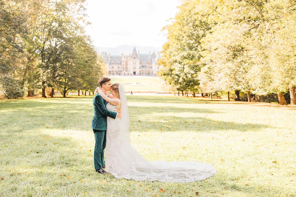 bride hugs groom while he kisses her forehead during fall wedding portraits 