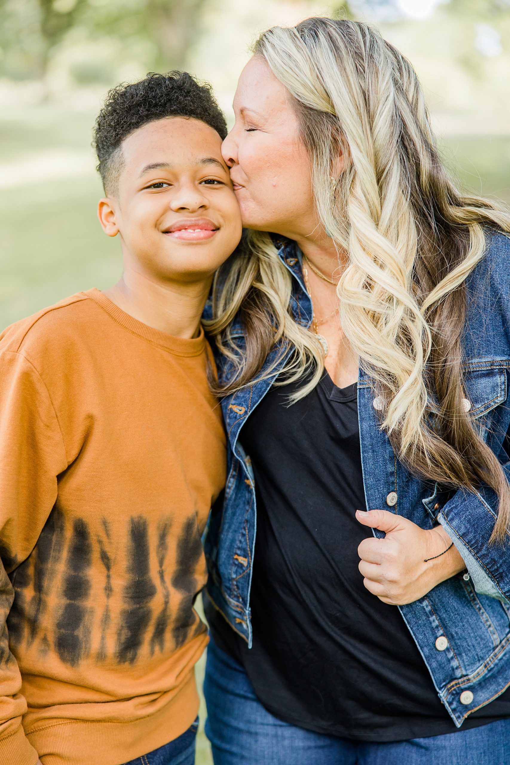 mom kisses son's temple during family photos in Charlotte NC 