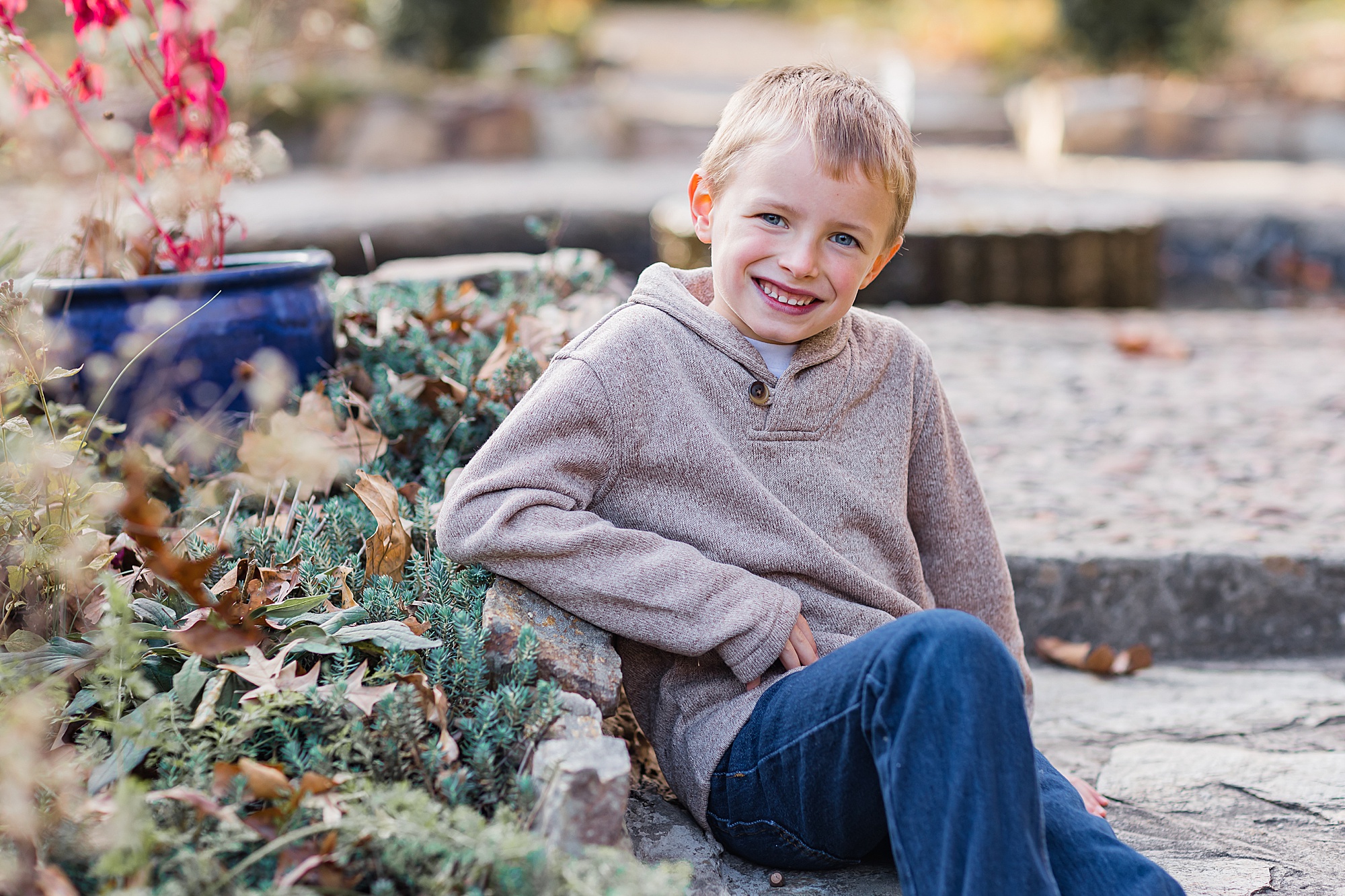 boy sits on stone steps during mini sessions at The Ivy Place