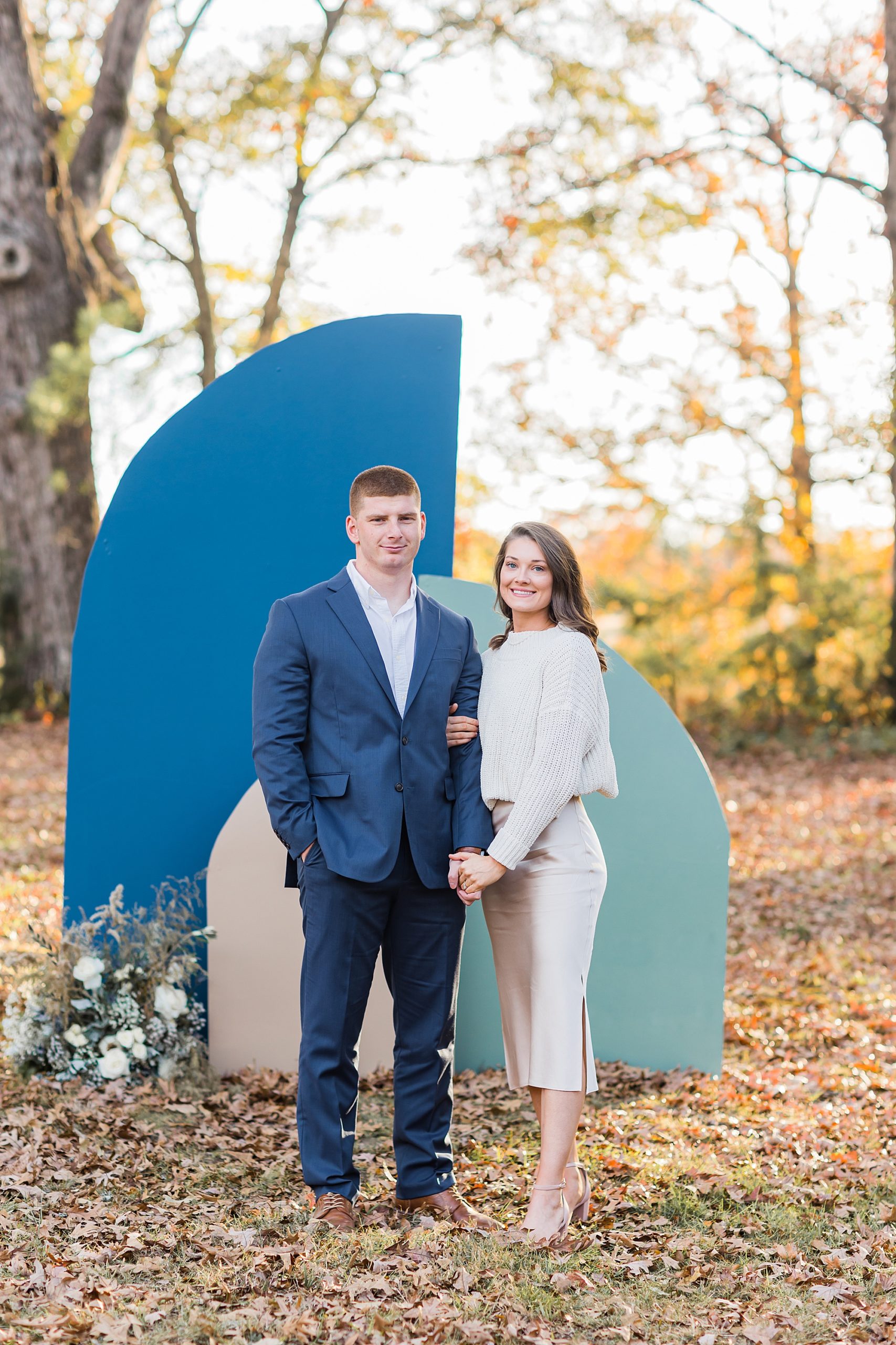 engaged couple stands by blue backdrop during The Ivy Place mini sessions