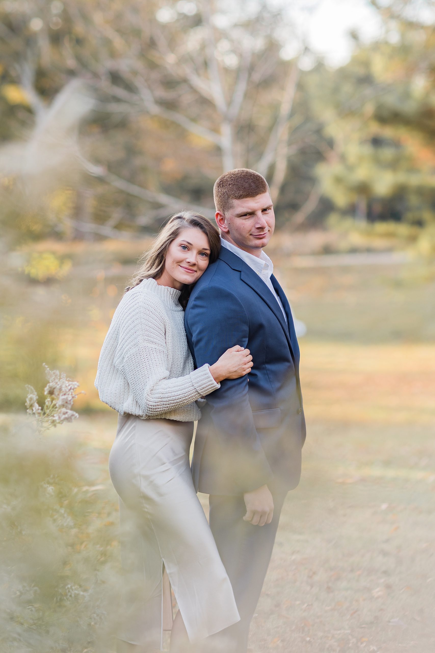 woman leans against man's back during portraits at The Ivy Place