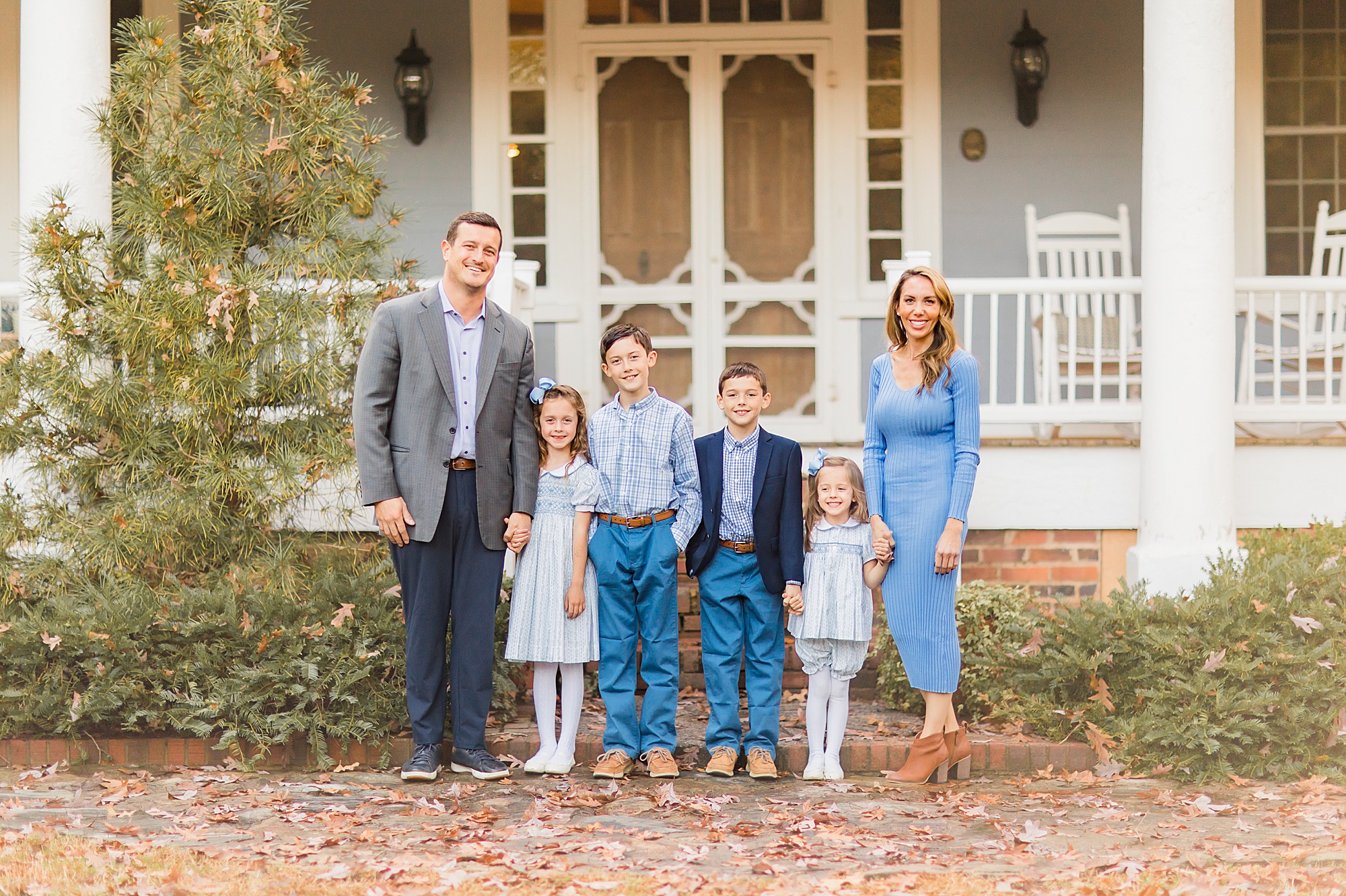 family of six poses outside The Ivy Place during mini sessions
