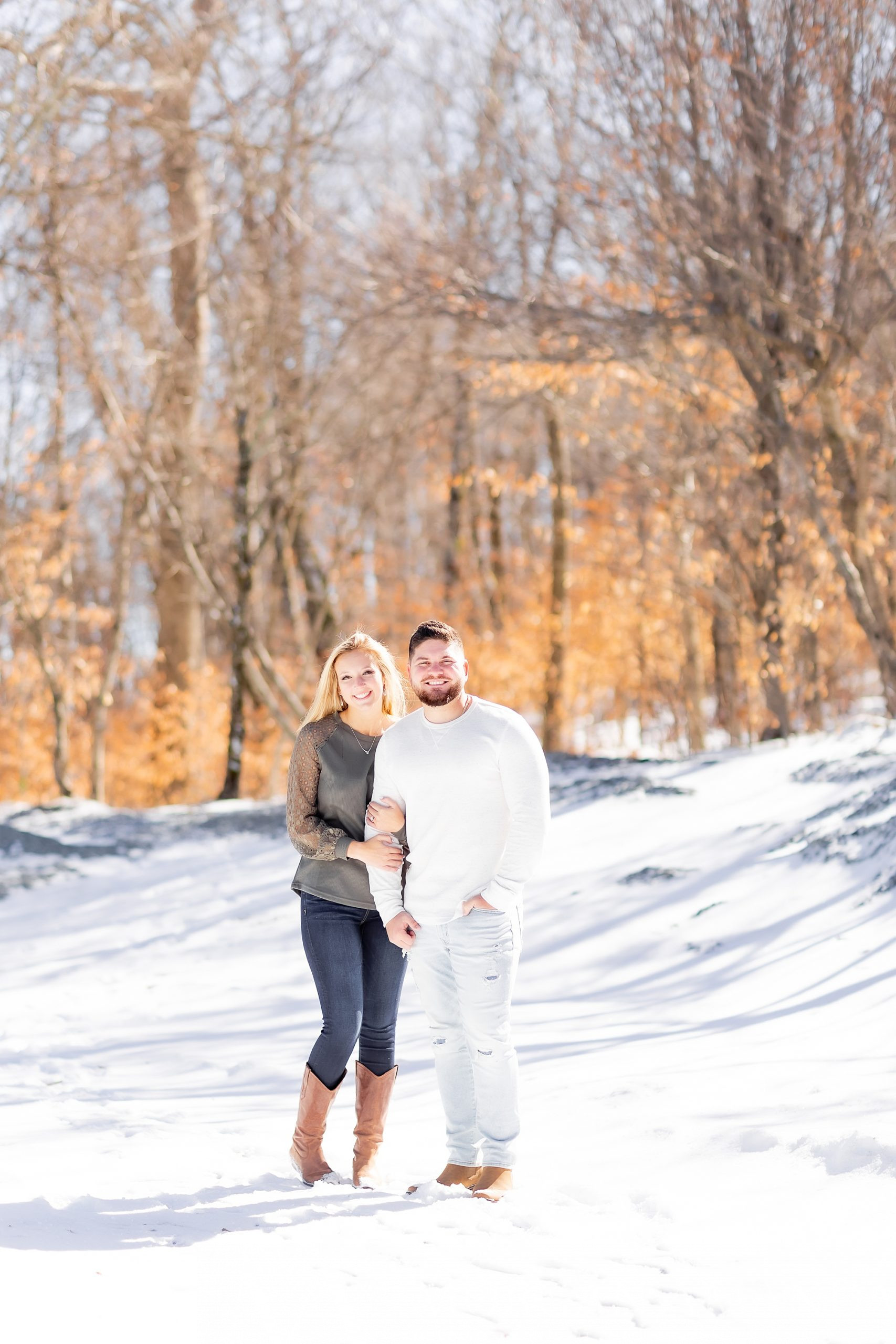 bride and groom hold hands in the snow during engagement photos at Beech Mountain
