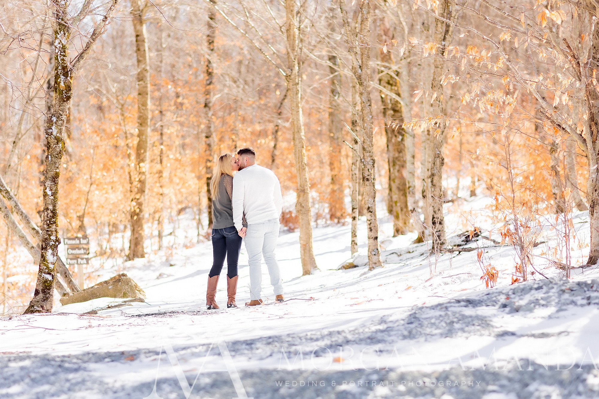 bride and groom kiss in snow during engagement session