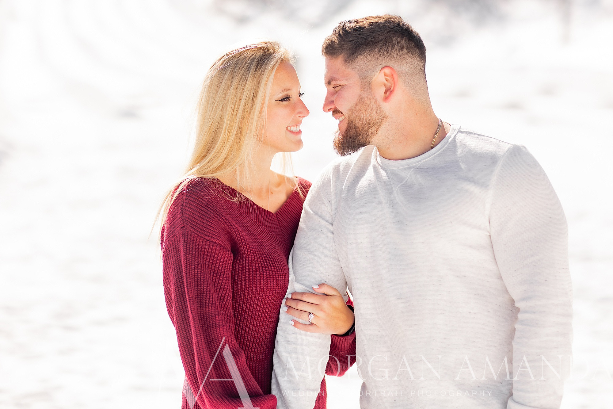 bride and groom smile together during wintery engagement photos at Beech Mountain