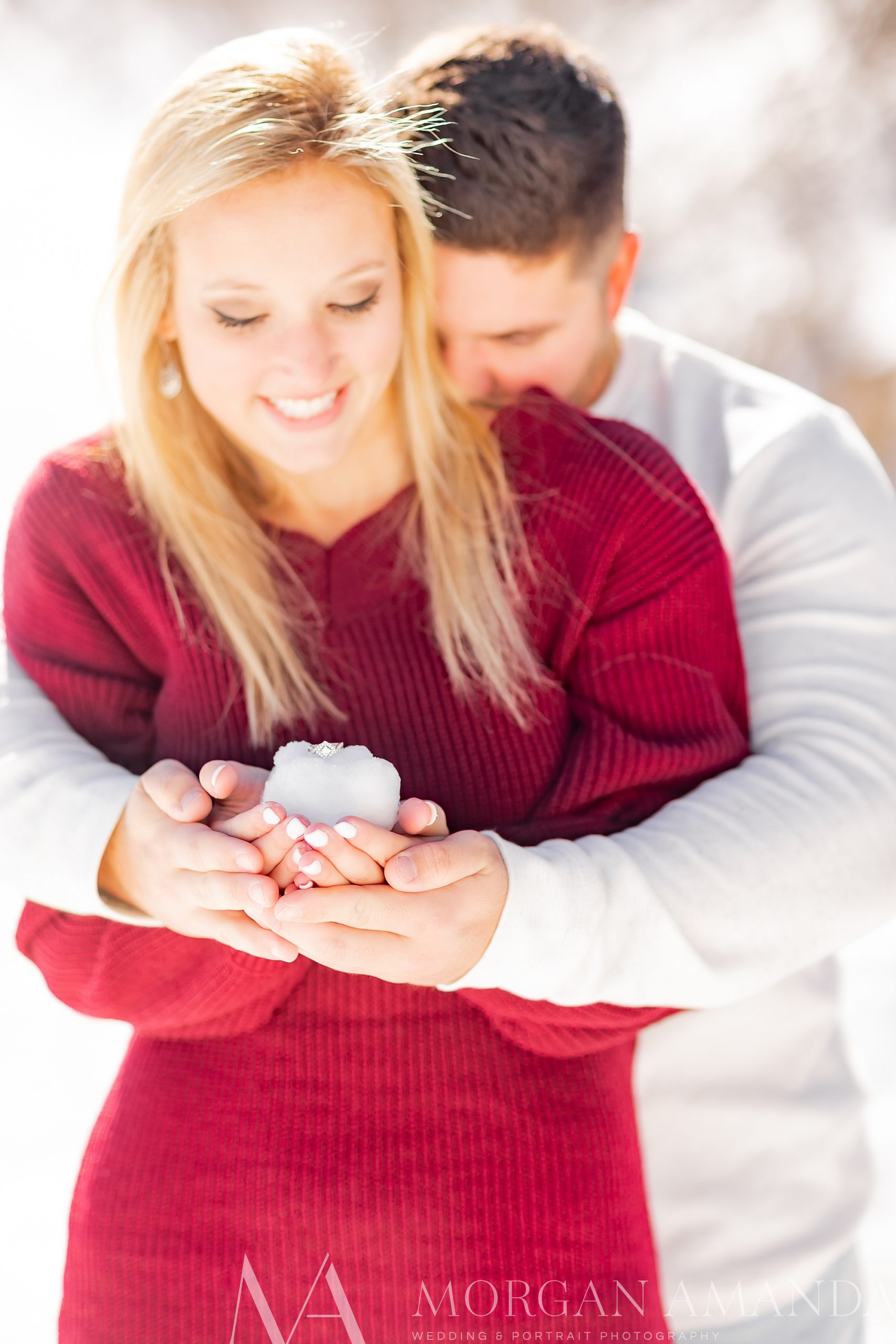 bride and groom hold snowball together during engagement photos