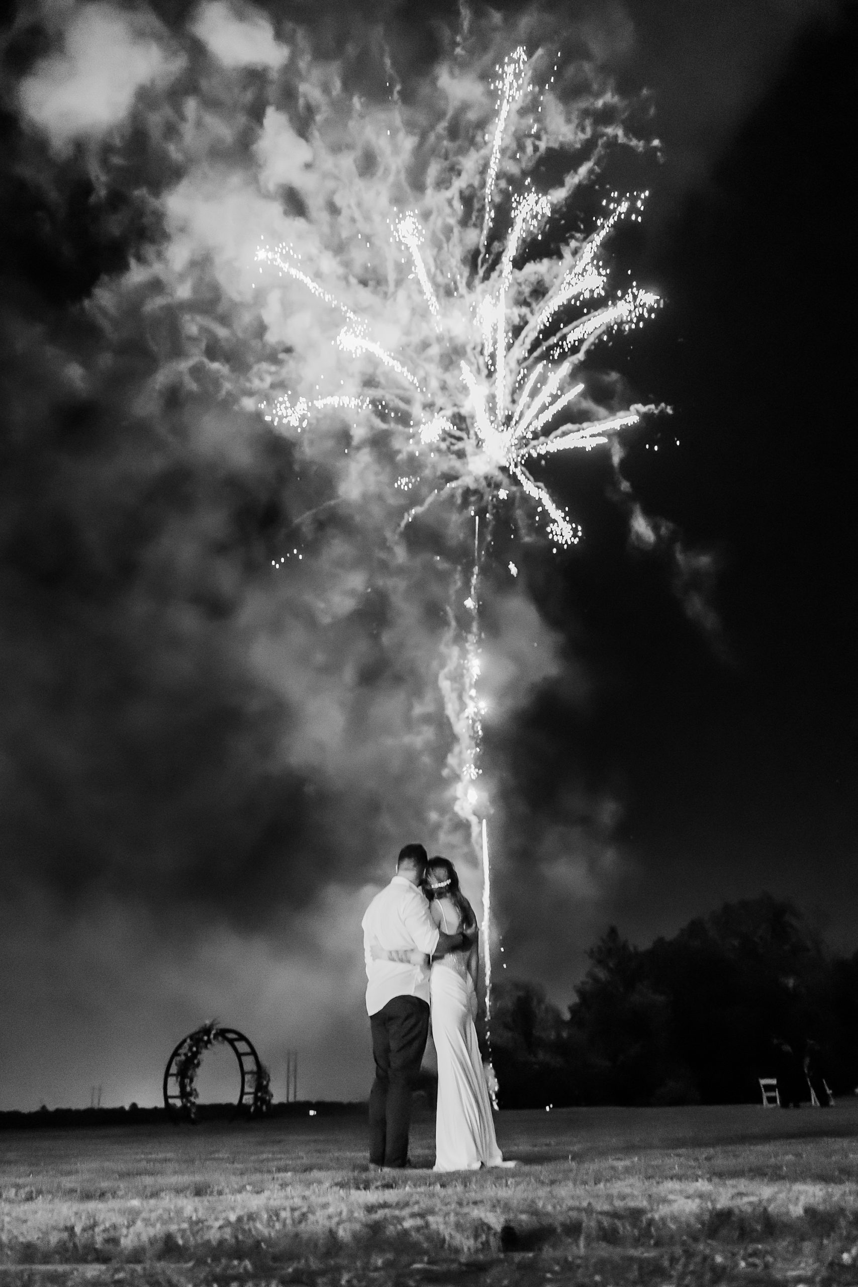 bride and groom hug during fireworks display at John's Island
