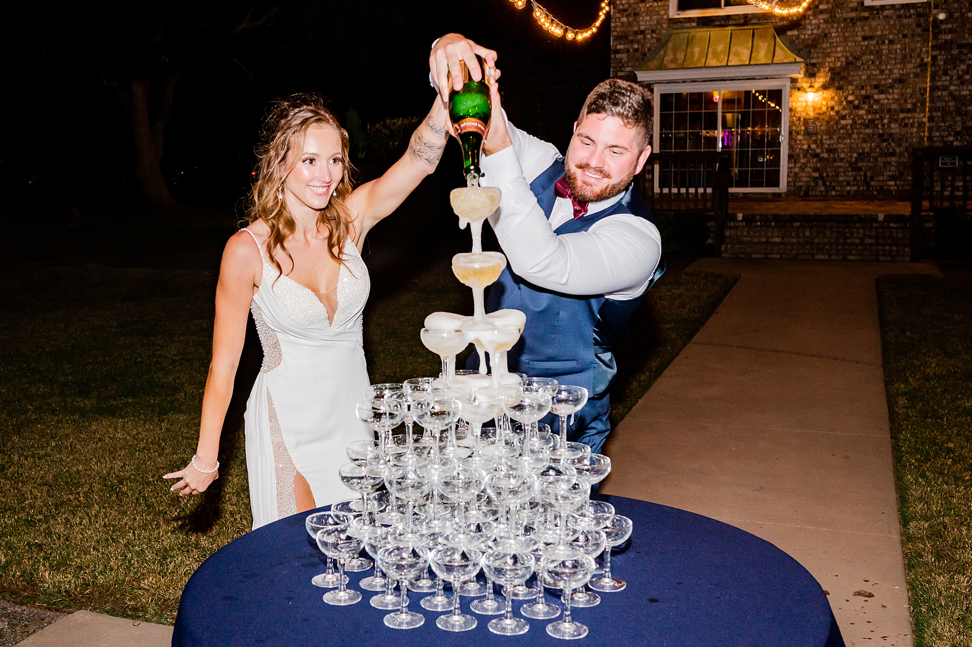newlyweds pour champagne over tower of glasses during John's Island reception 