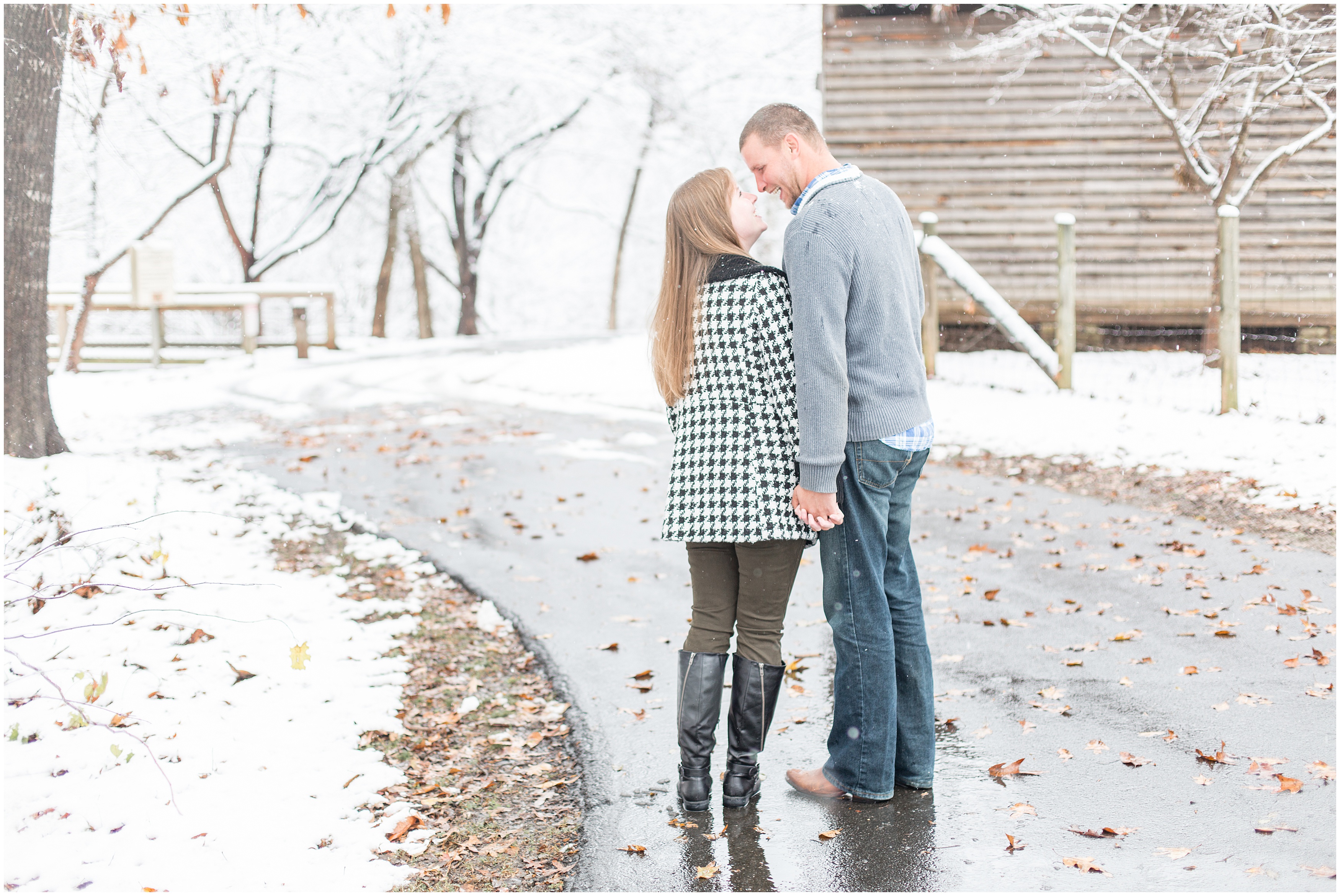 engaged couple lean in for a kiss in snow covered street of GA