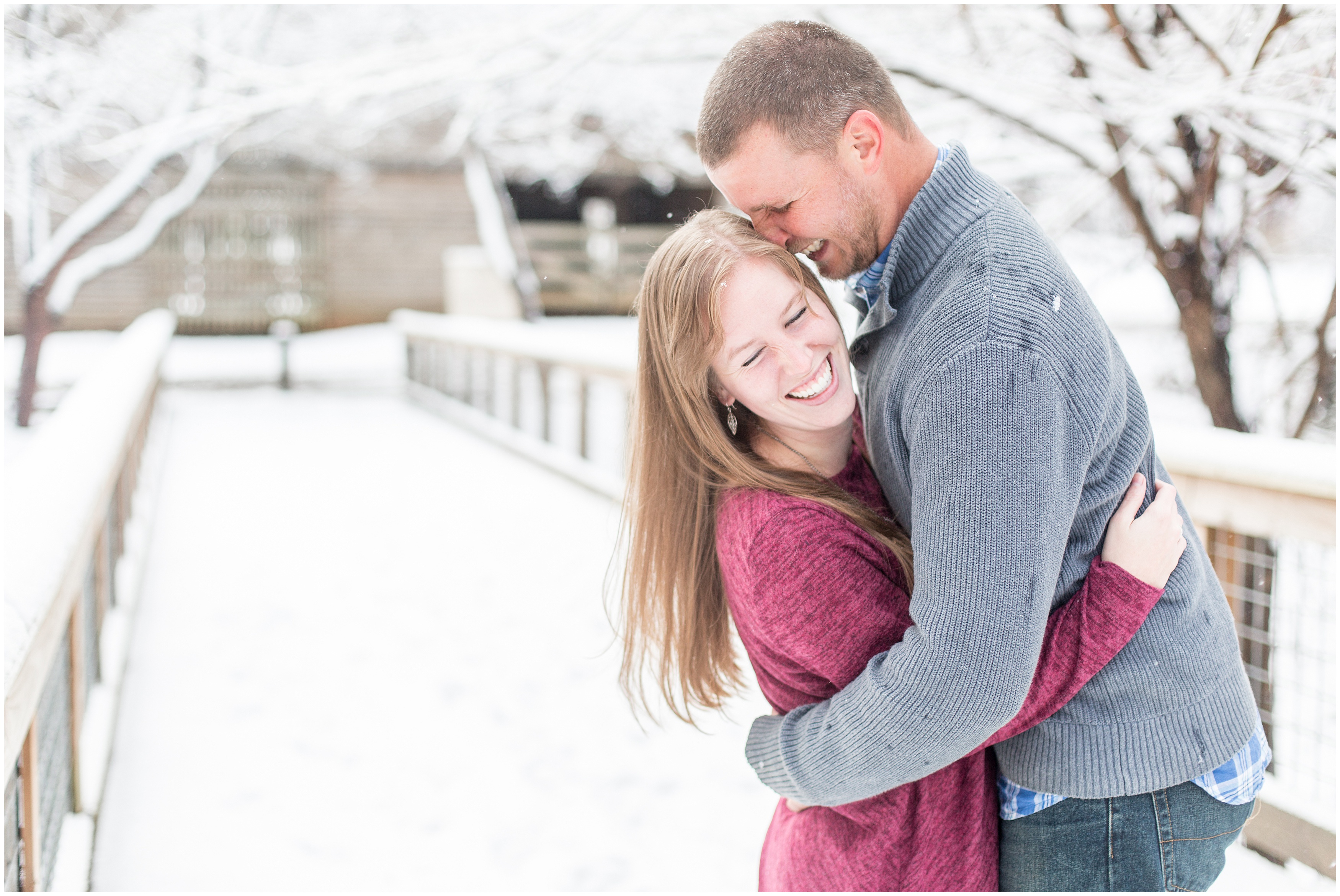 engaged couple share laughs during their snow filled engagement session