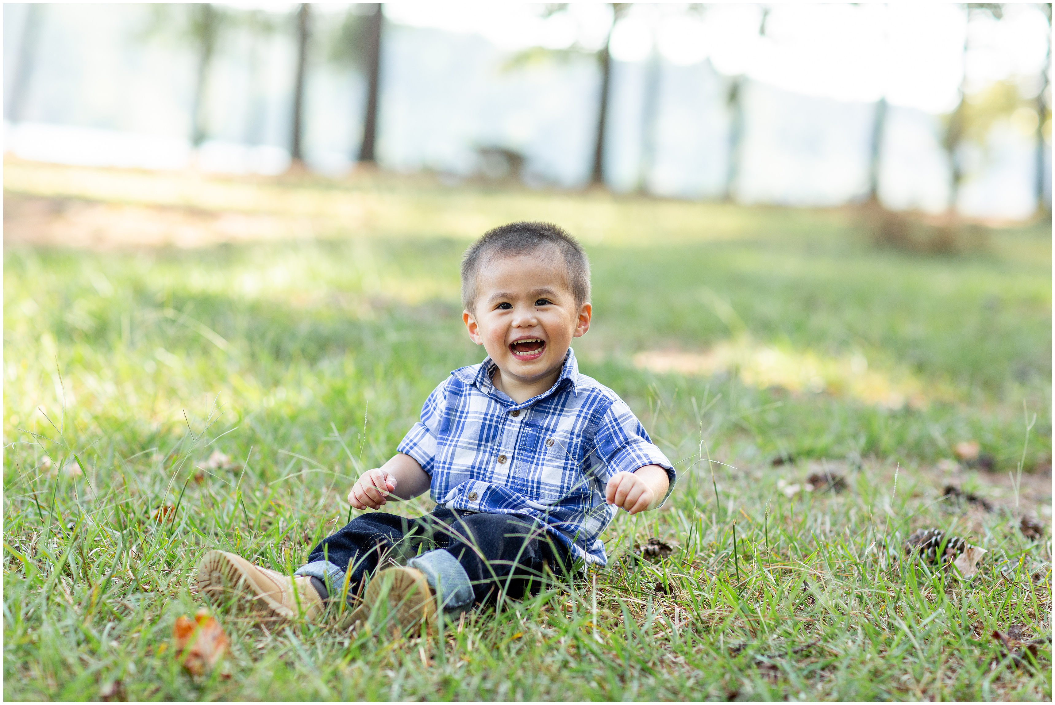 toddler poses in grass during family photos