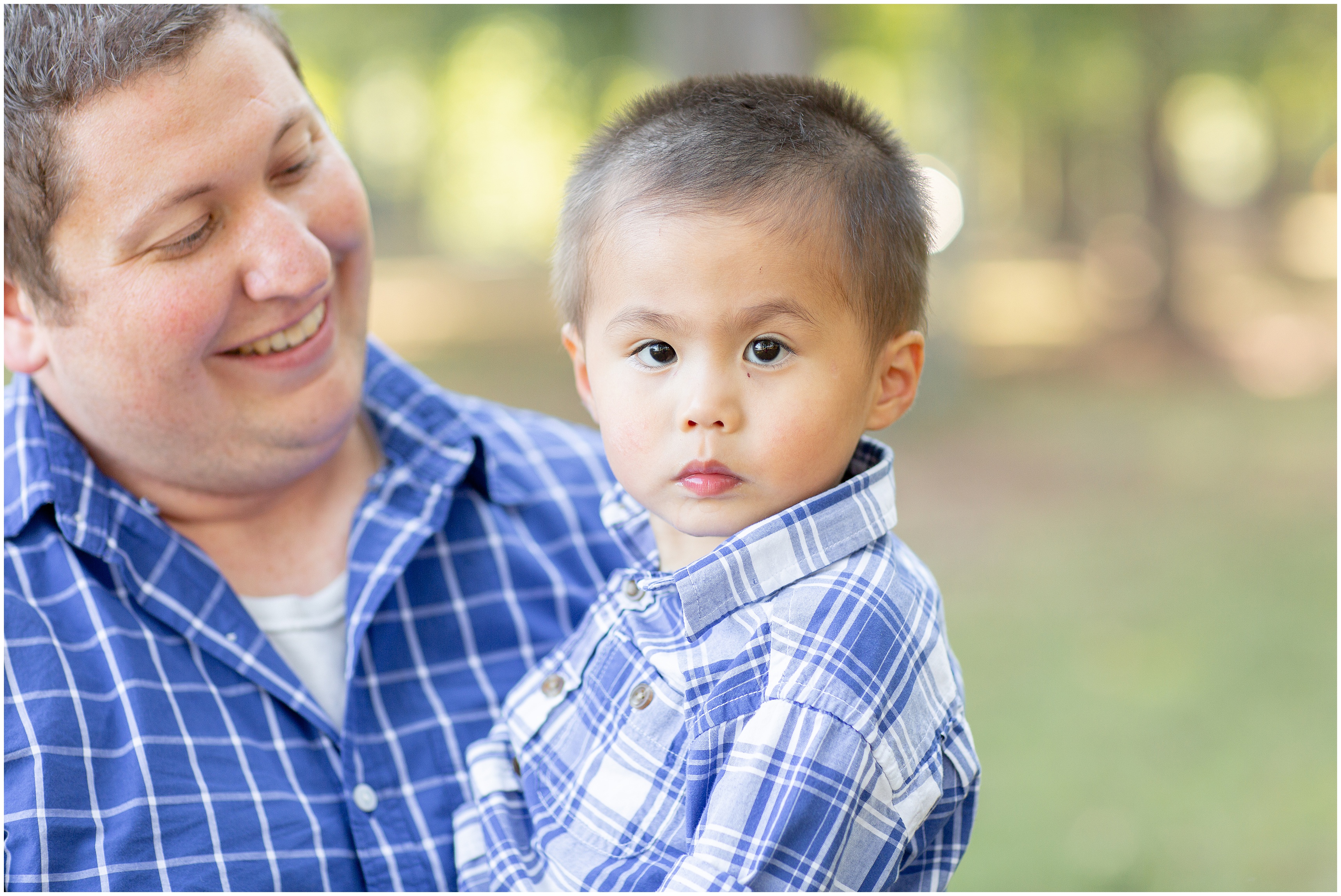 dad looks at son while he looks at photographer