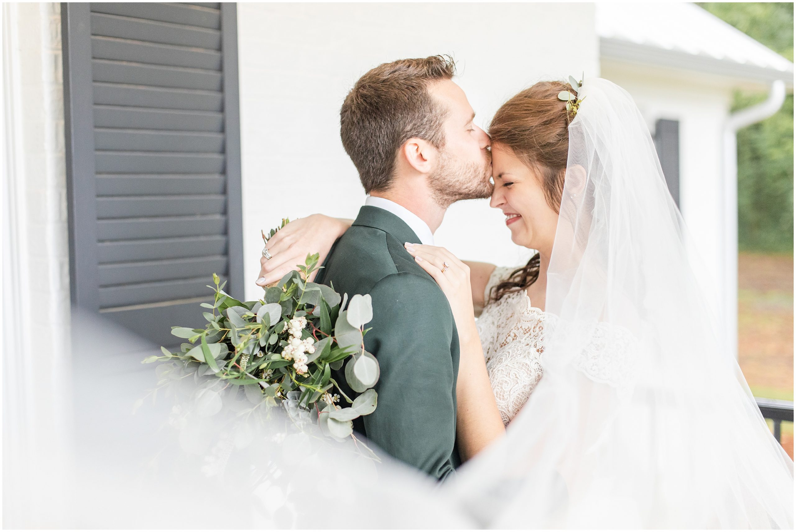 groom kisses bride's forehead during AL wedding photos