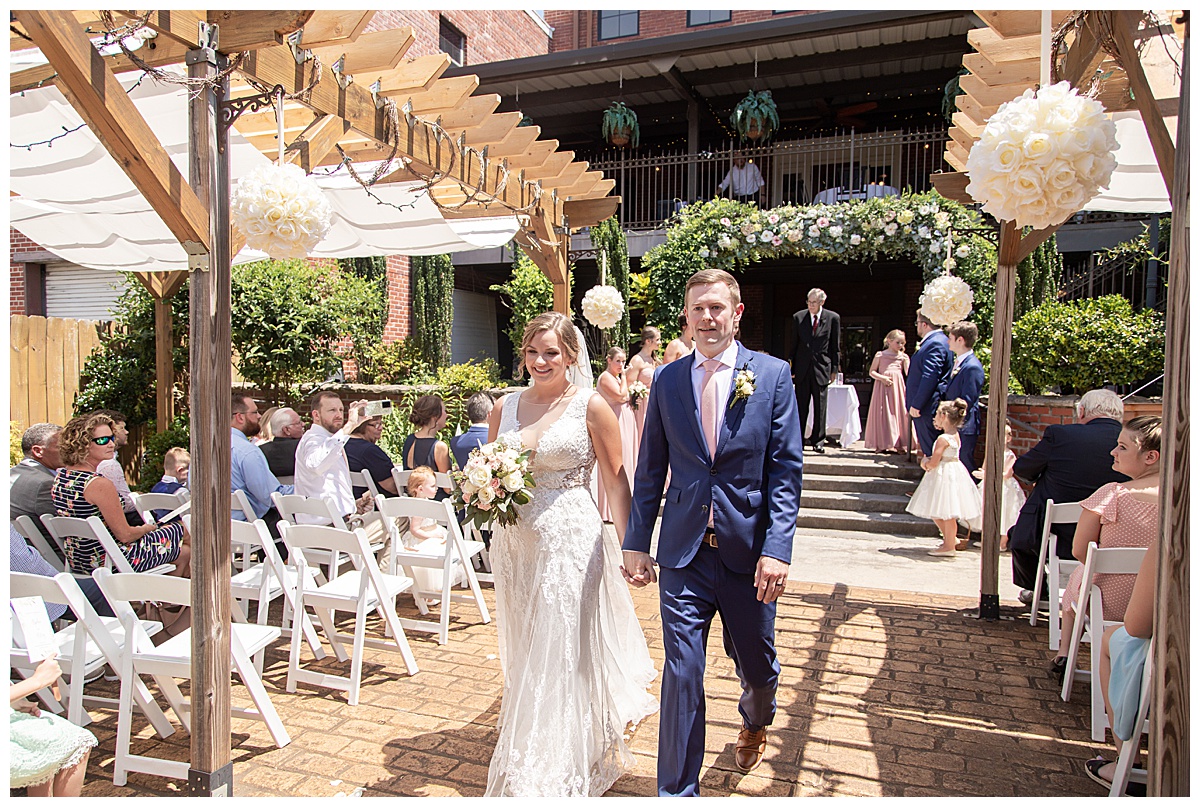 bride and groom walk up aisle at The Conservatory at Waterstone