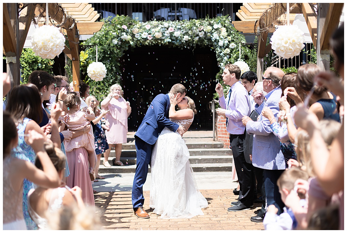 bride and groom kiss after outdoor ceremony at The Conservatory at Waterstone