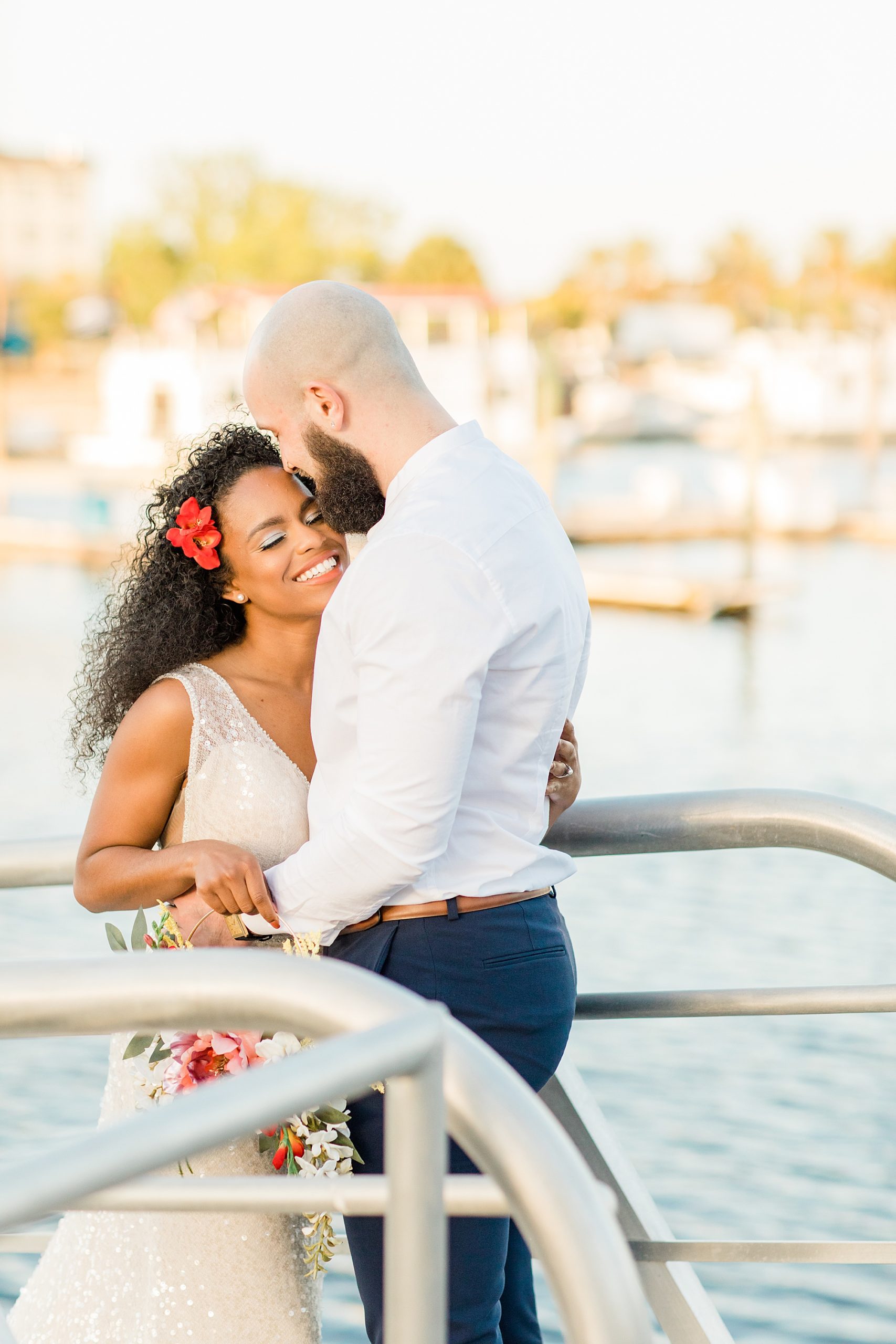 groom hugs bride by waterfront during Disney Inspired Wedding