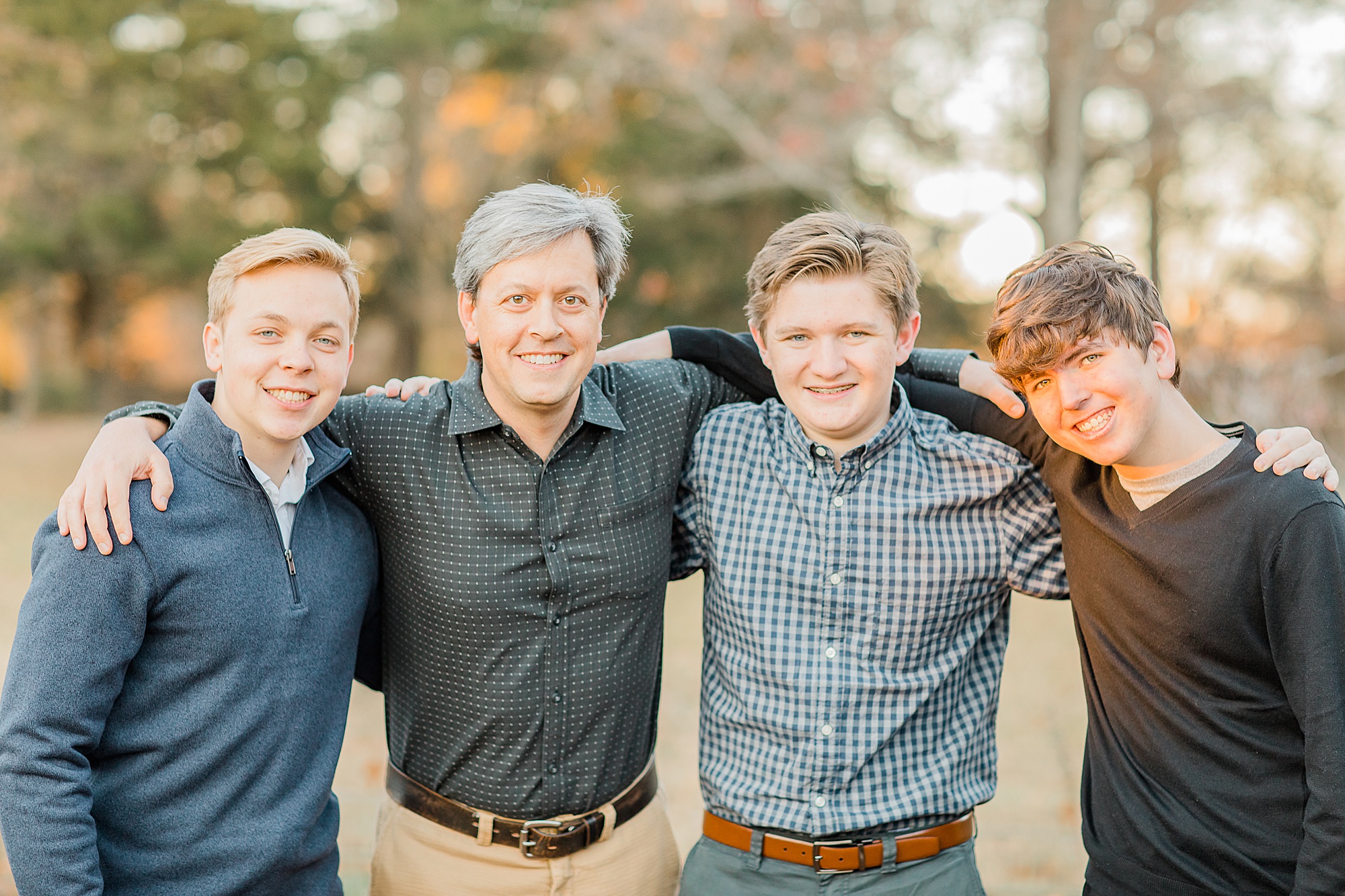 dad hugs sons during family photos in Charlotte NC