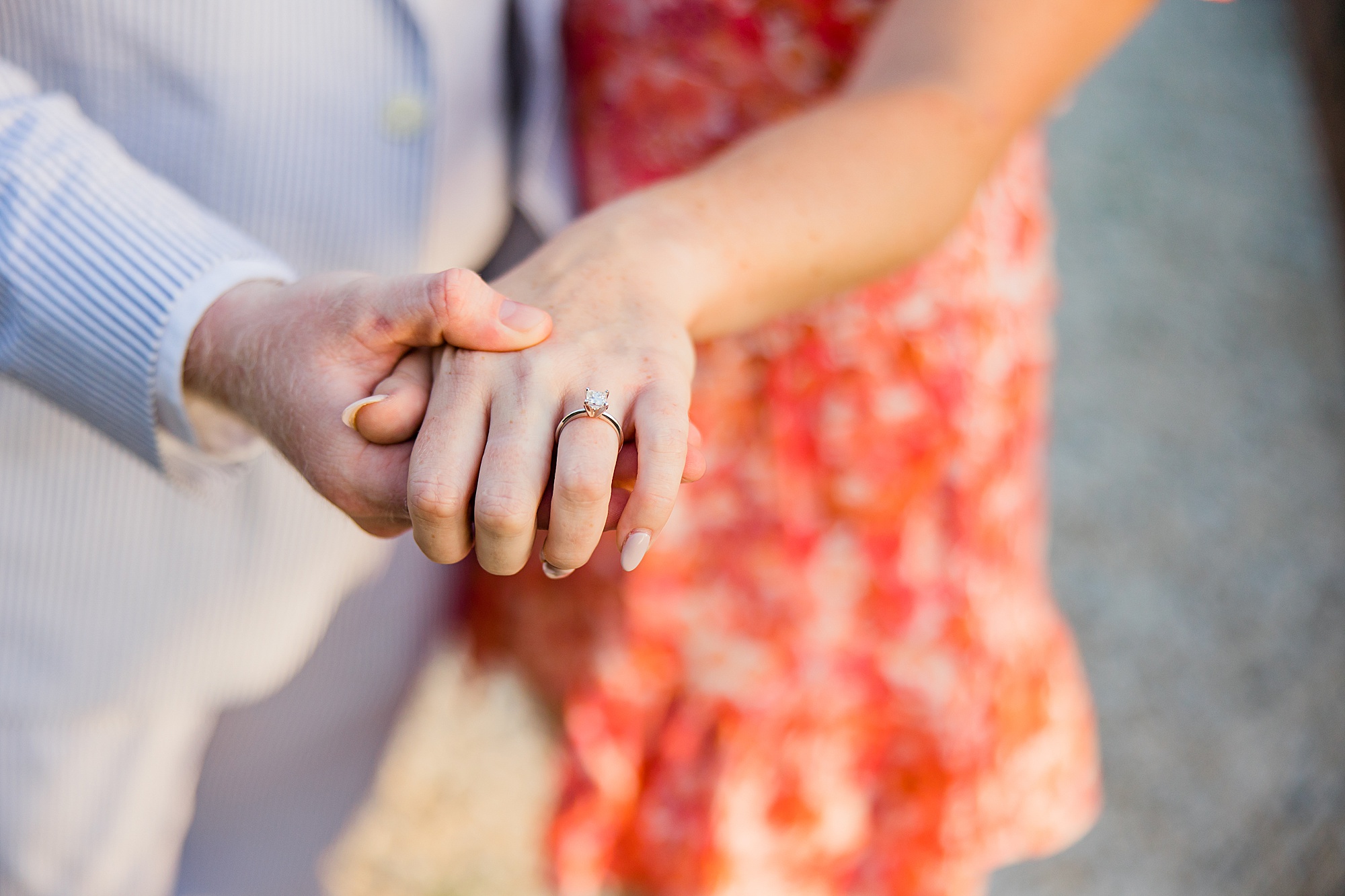 bride and groom hold hands showing off ring
