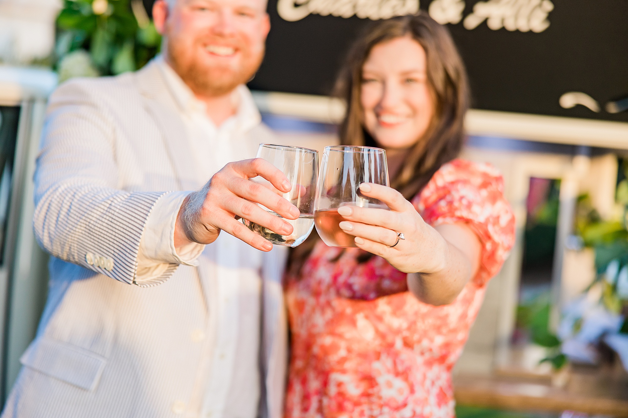 bride shows off engagement ring with wine glass