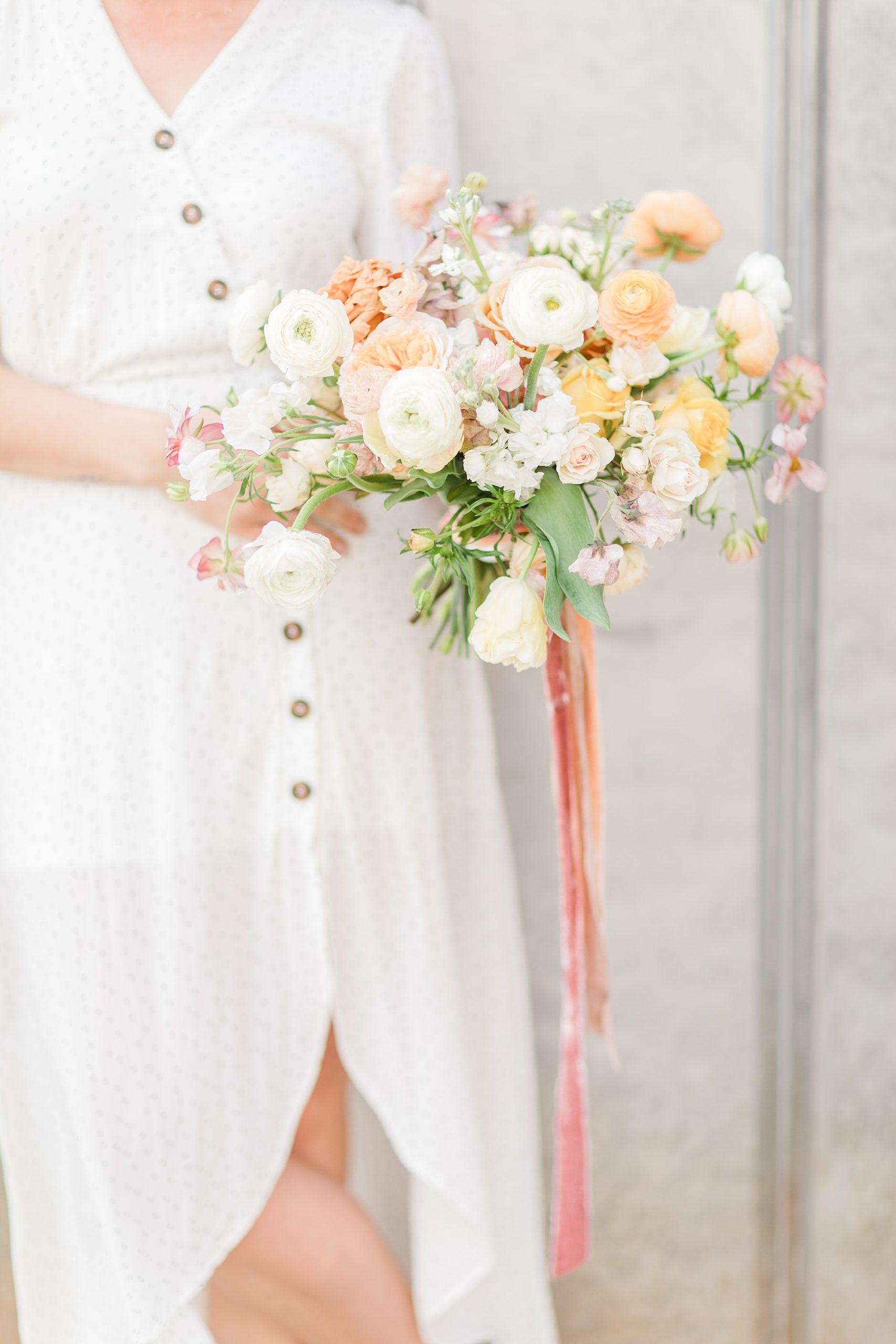 planner holds bouquet of white and yellow flowers