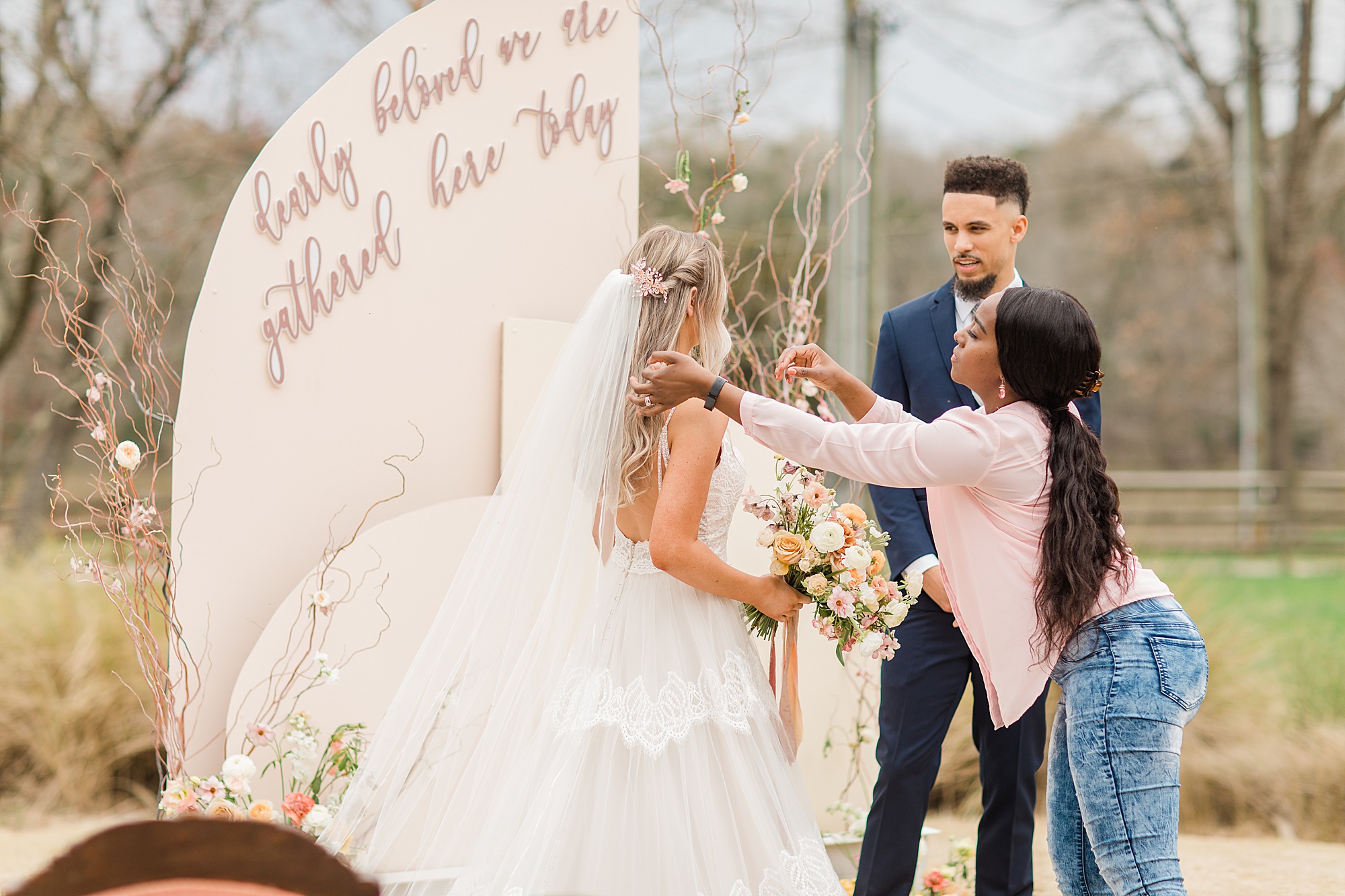 planner helps bride with veil during styled shoot