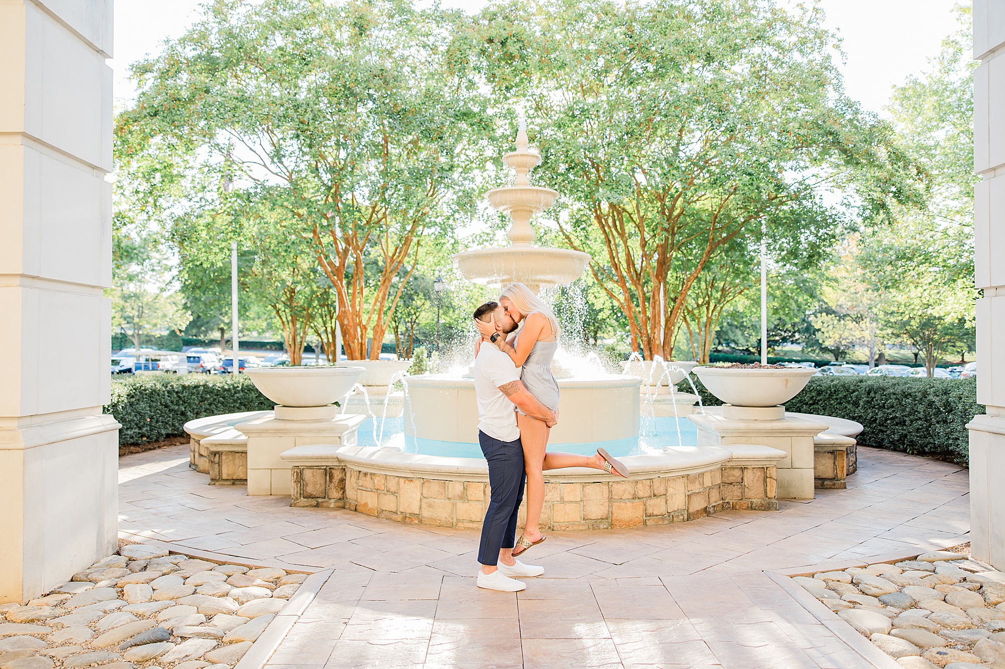 engaged couple hugs by fountain in Charlotte NC